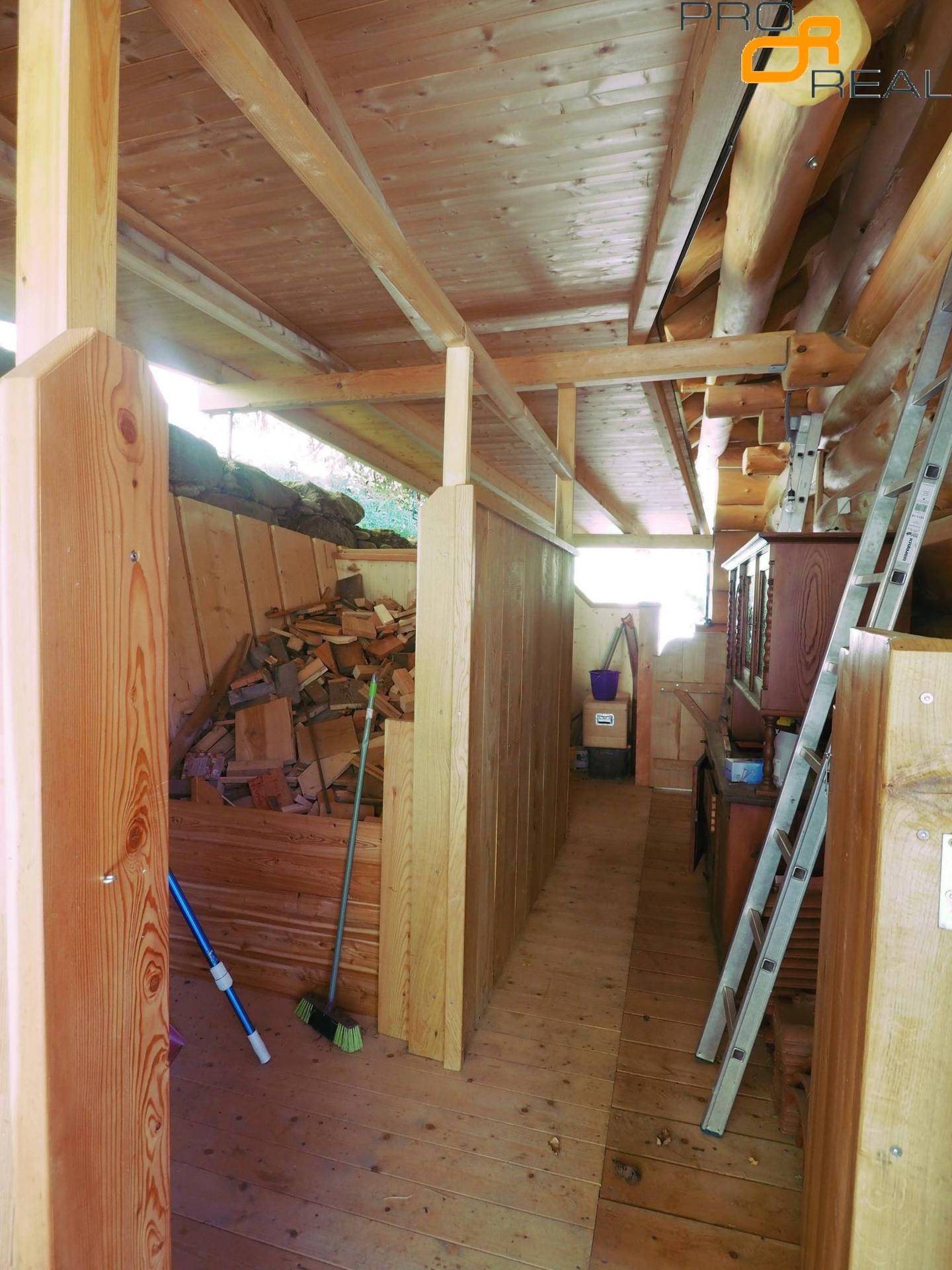 Geräumiger Dachboden mit Holzbalken und gelagertem Brennholz.