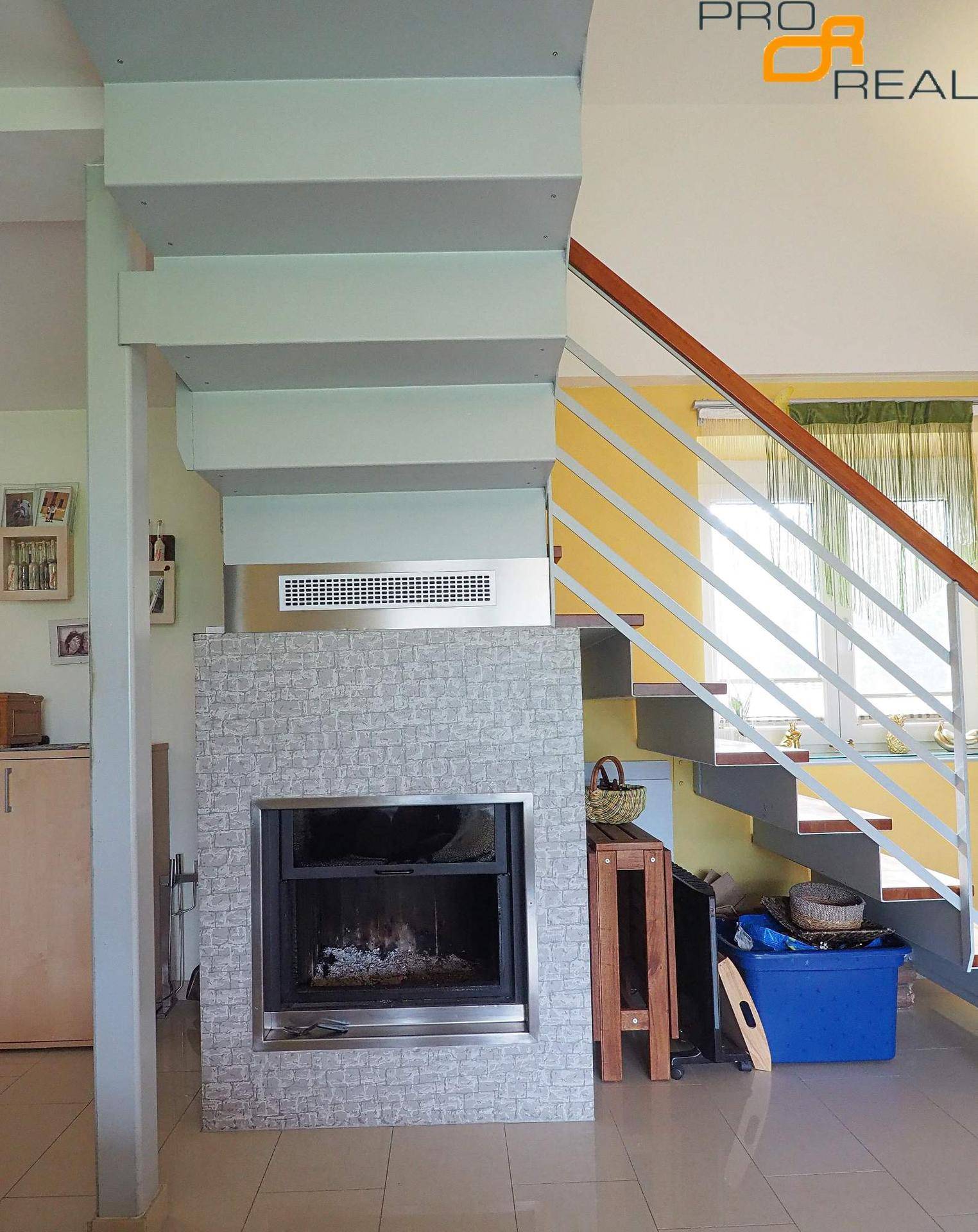 Moderner Kamin, elegant in eine geflieste Wand integriert, mit einer Treppe darüber.