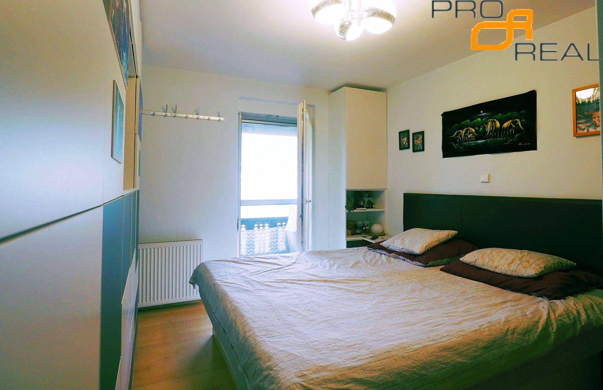 Schlafzimmer mit Doppelbett, Einbauschrank und Zugang zu einem Balkon, hell und freundlich.