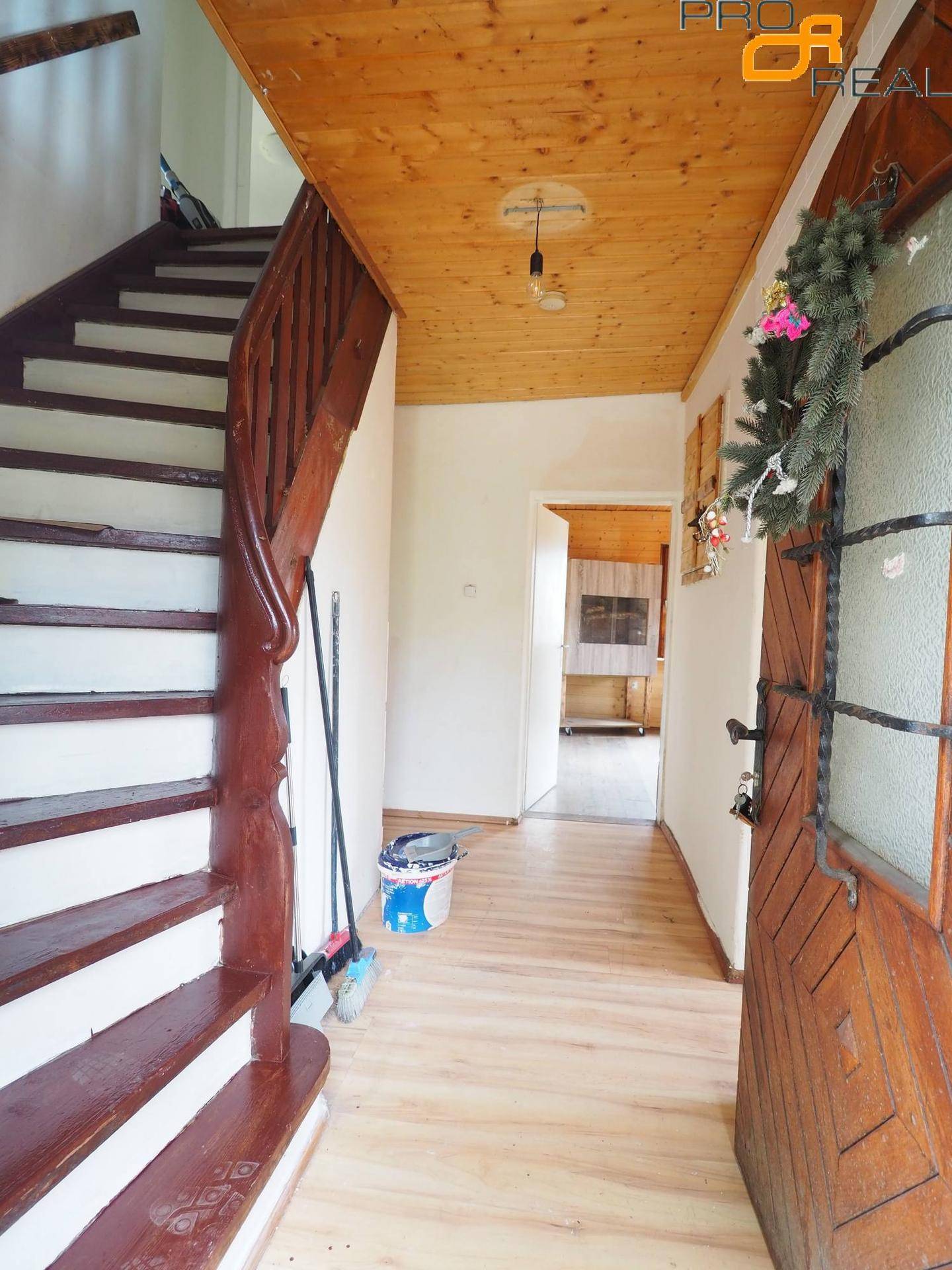Eingangsbereich mit Holztreppe, Holzboden und Zugang zu weiteren Räumen.