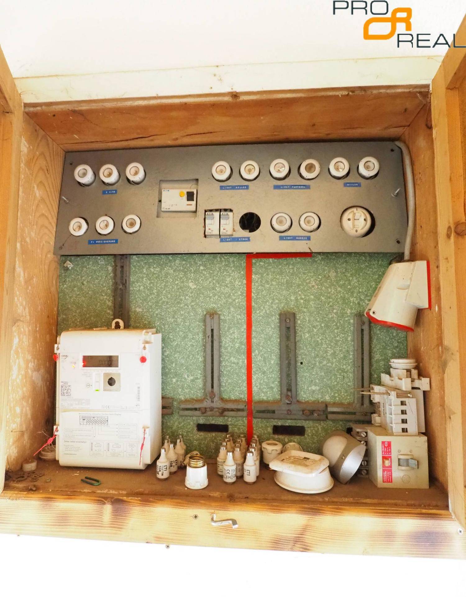 Hauswirtschaftsraum mit altem Sicherungskasten und verschiedenen elektrischen Komponenten.