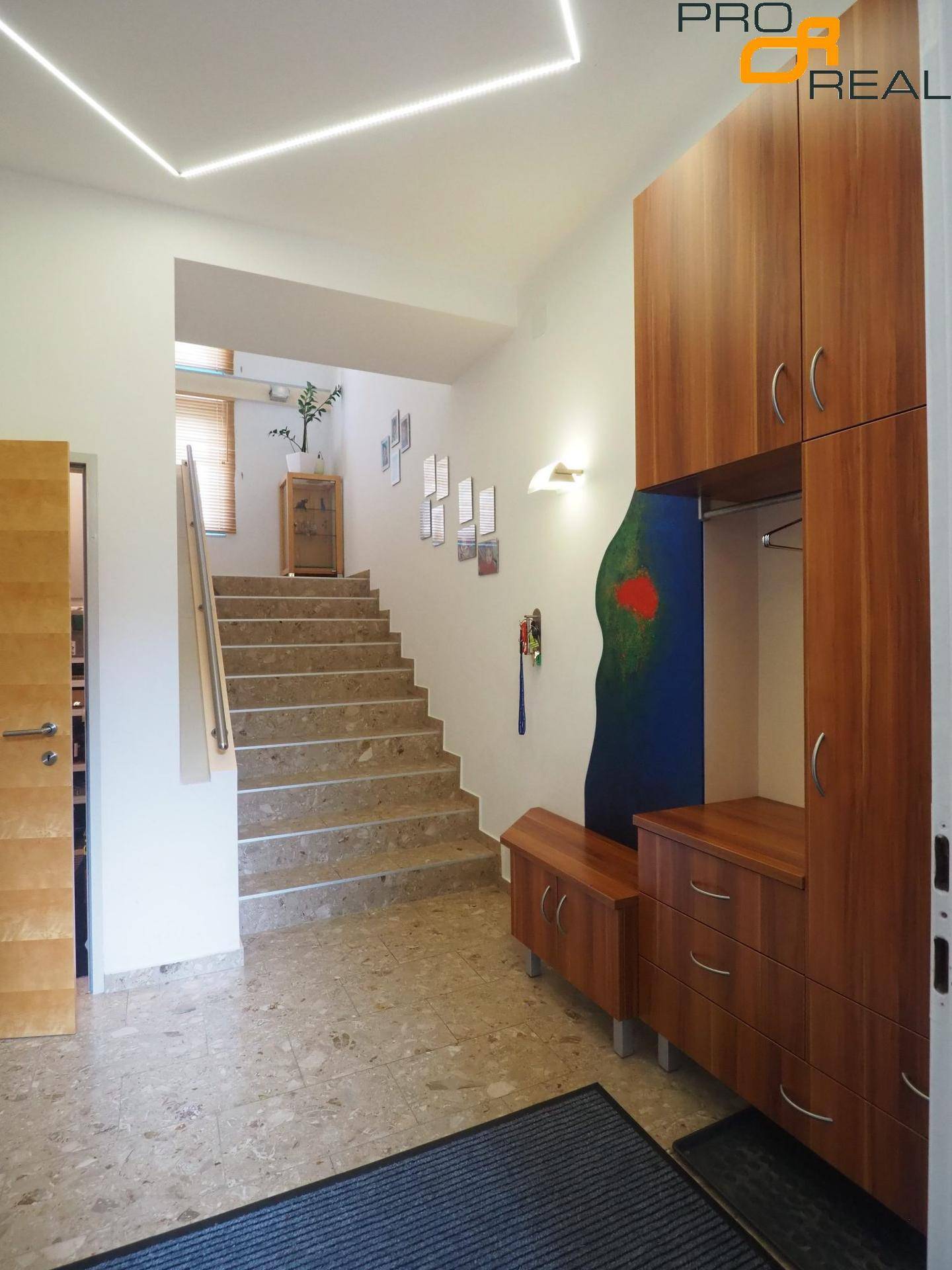 Geräumiger Flur mit Steintreppe, Einbauschränken aus Holz und moderner Deckenbeleuchtung.