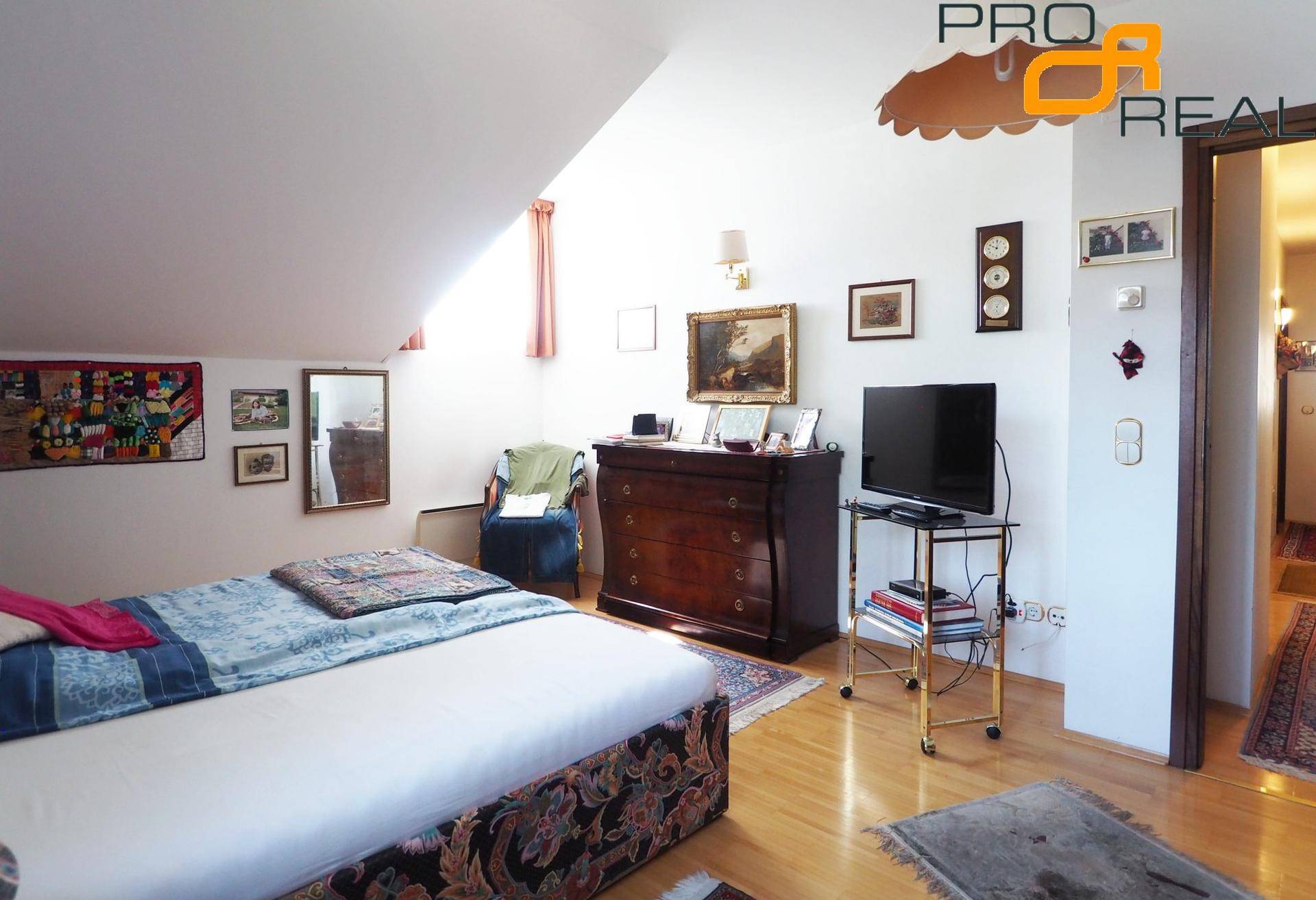 Geräumiges Schlafzimmer mit Holzboden, Kommode und Blick auf den Flur.