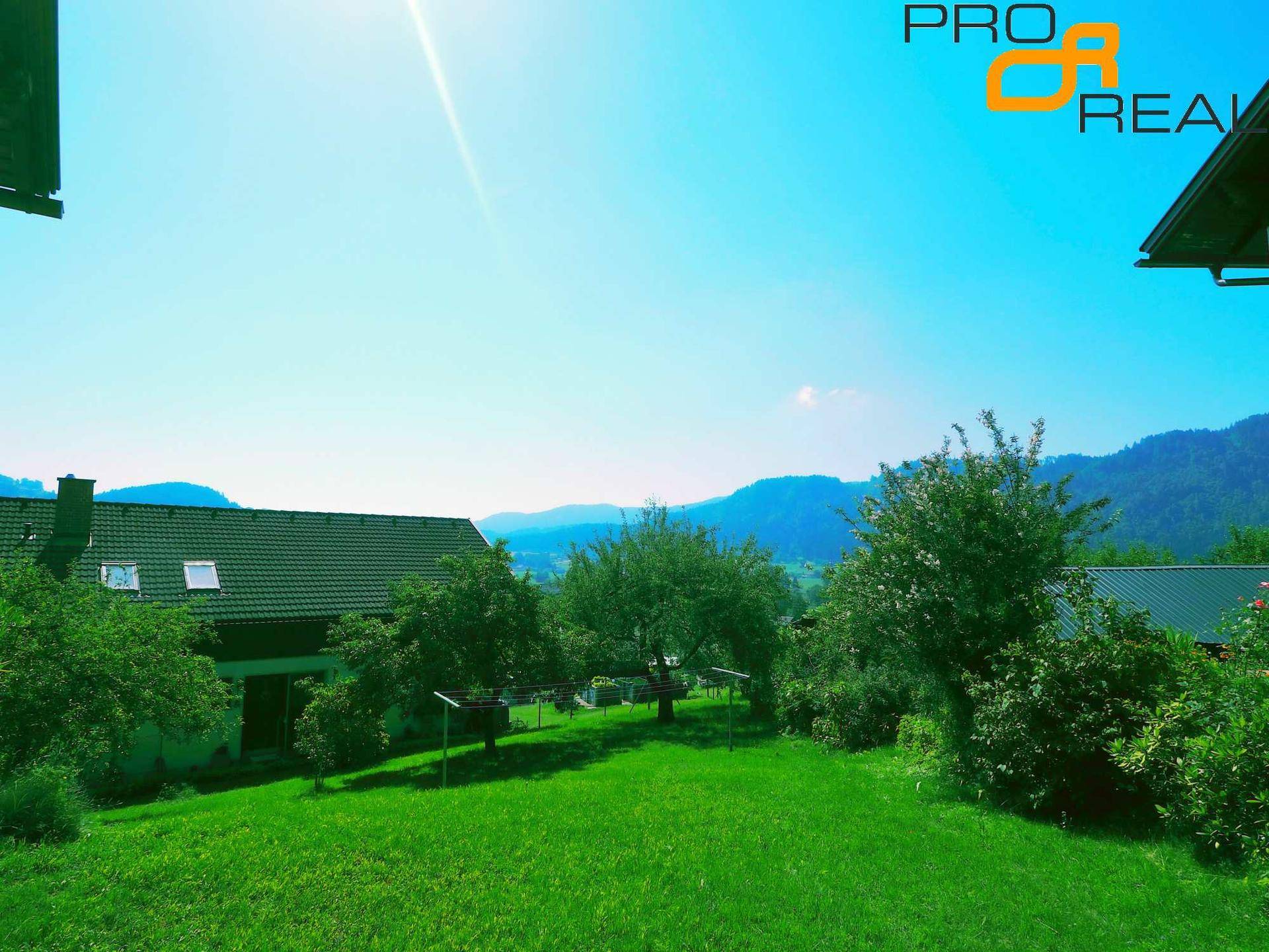 Weitläufiger grüner Garten mit Blick auf die Berge und die umliegende Natur.