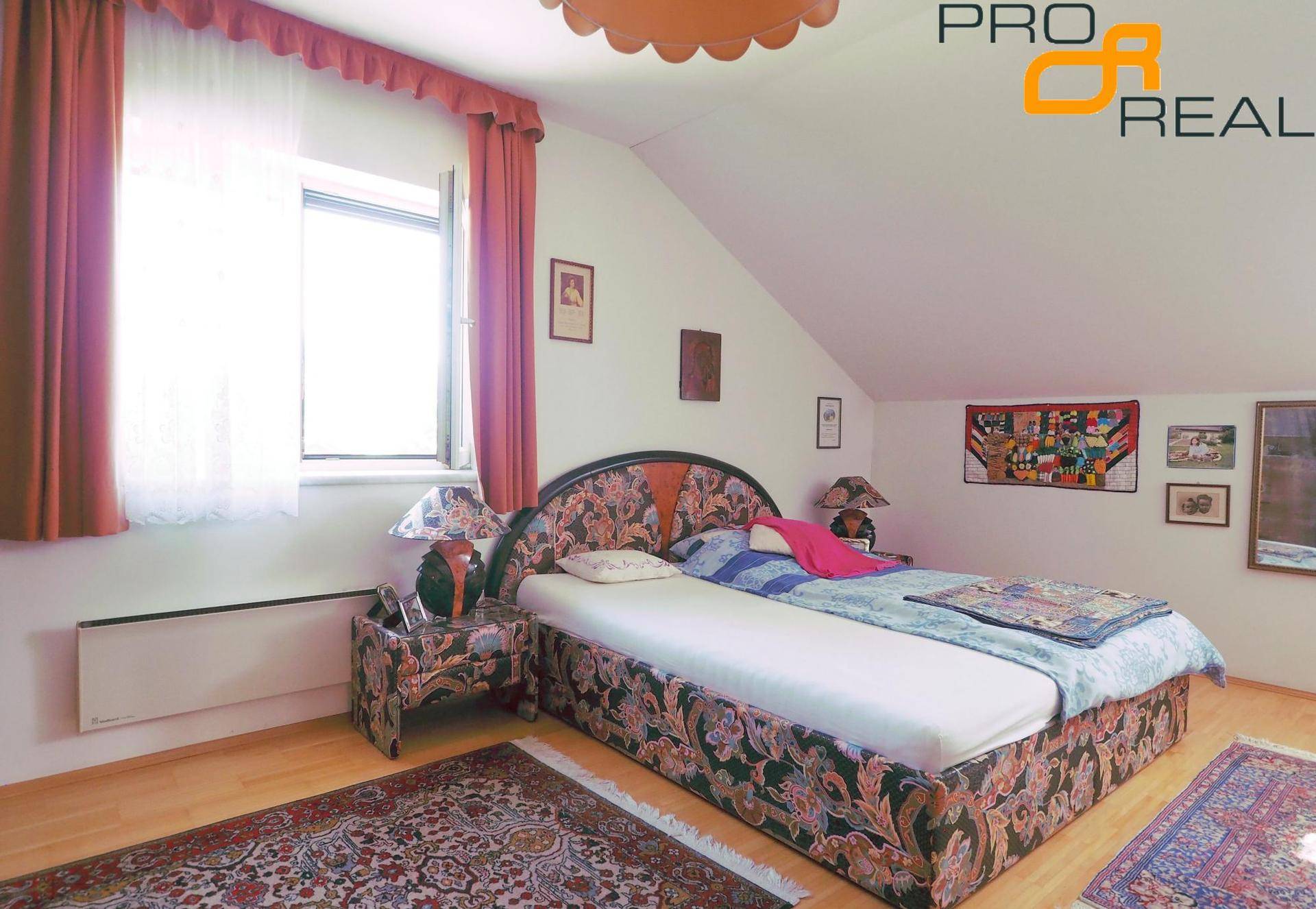 Schlafzimmer mit Holzboden, Dachschräge und traditionellem Doppelbett.