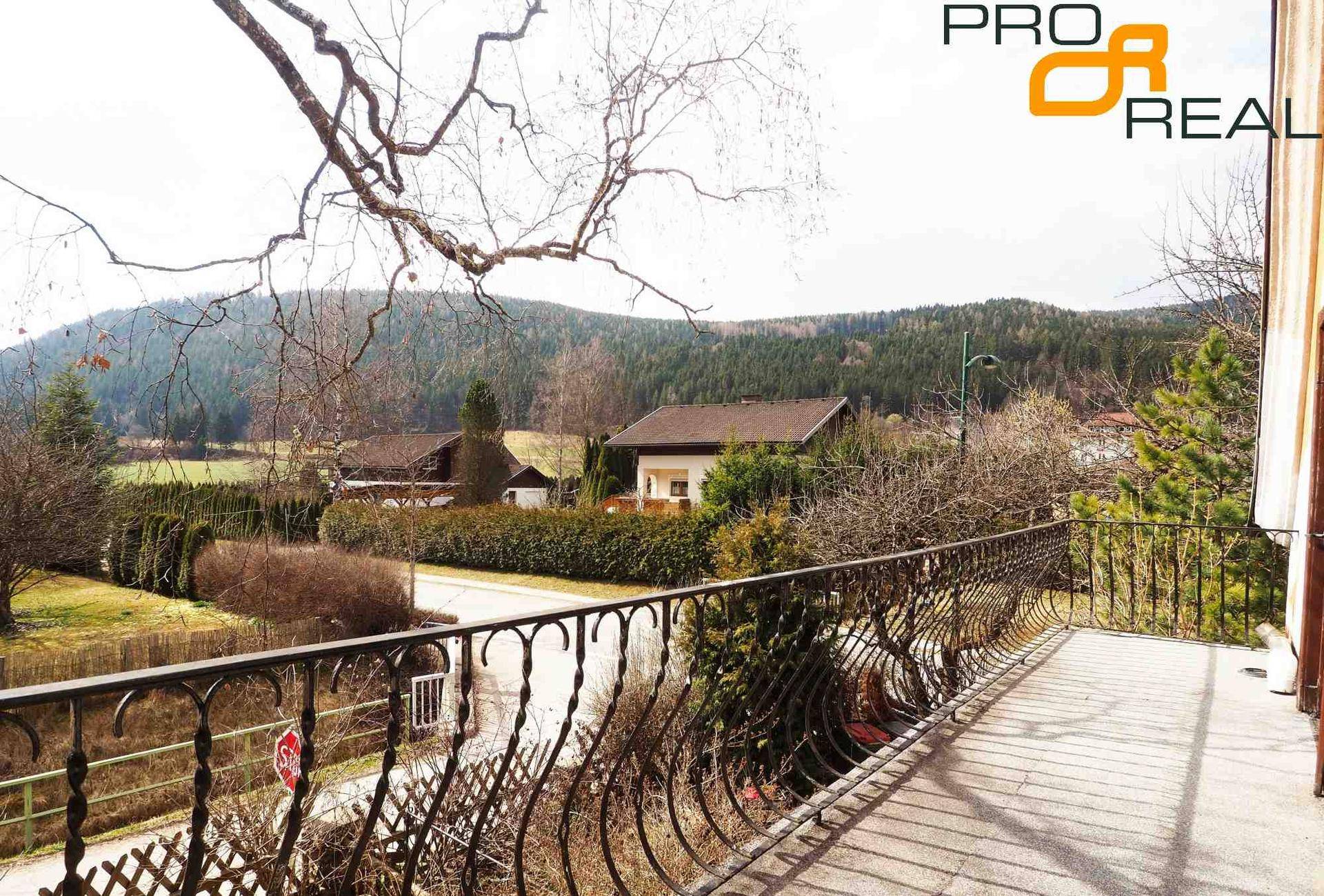 Geräumiger Balkon mit schmiedeeisernem Geländer und Panoramablick auf die umliegende Natur.