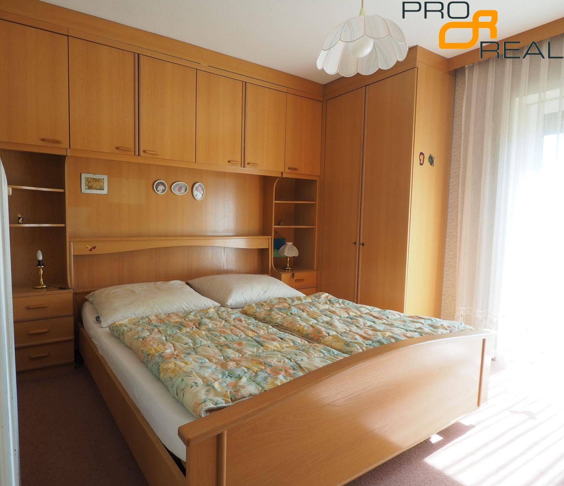 Schlafzimmer mit Einbauschränken, Doppelbett und hellem Fenster.
