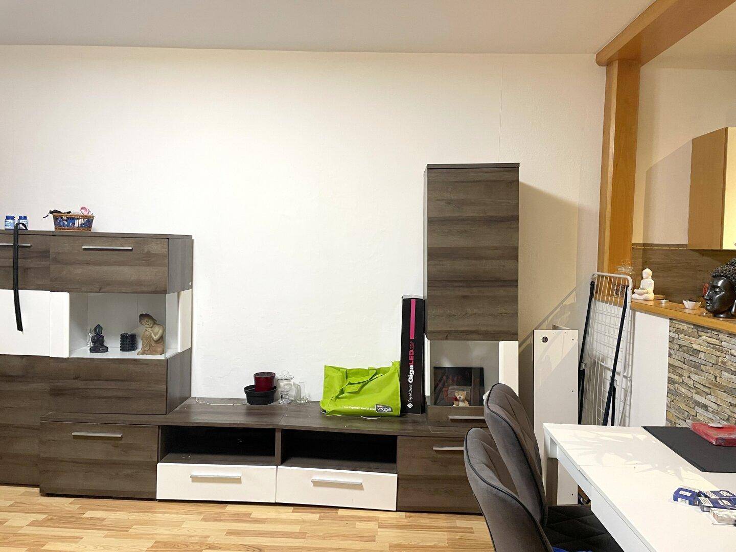 Wohnzimmer mit moderner Schrankwand, Holzboden und Blick auf den Essbereich.