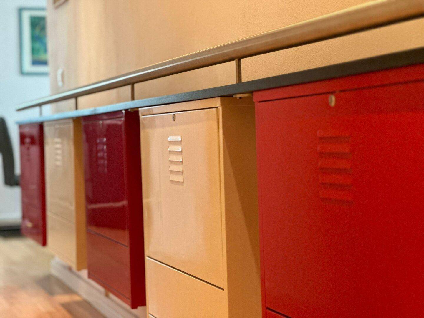 Nahaufnahme der modernen roten und beigen Schränke im Flur mit Lüftungsschlitzen.