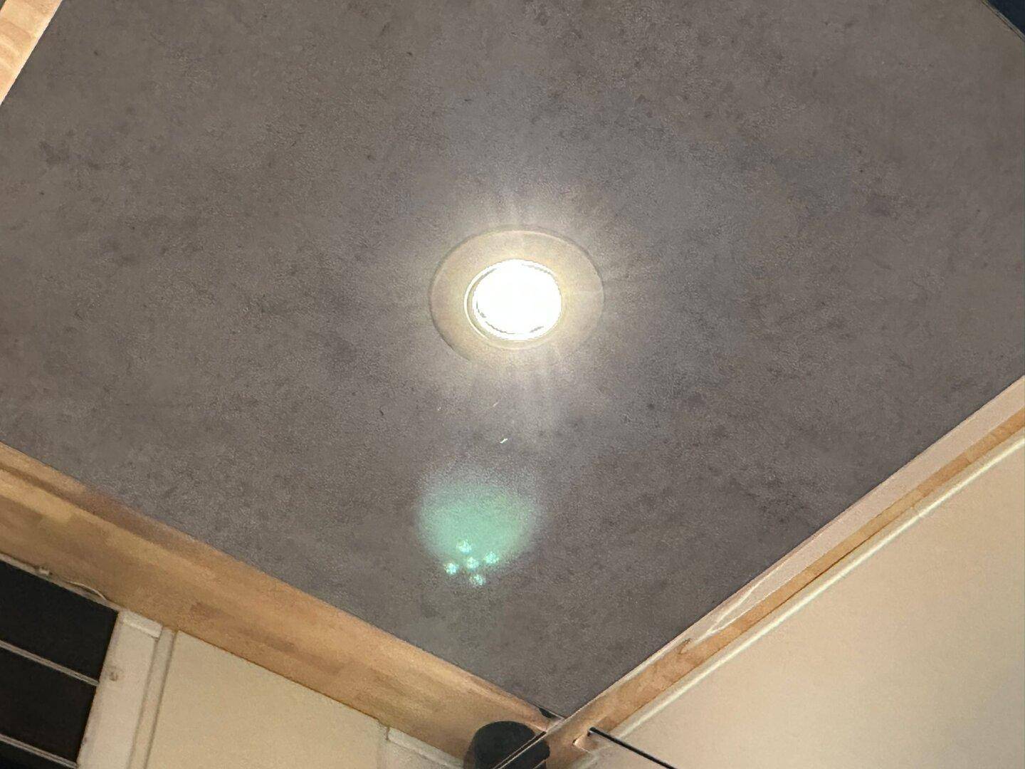Deckenleuchte in einer modernen Deckenverkleidung mit integrierten Spots.