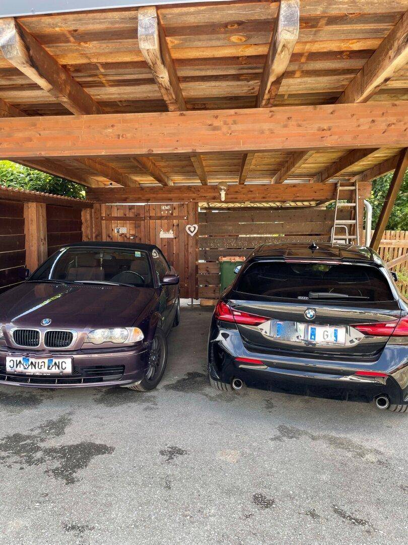 Überdachter Stellplatz für zwei Fahrzeuge unter einem Holzcarport.