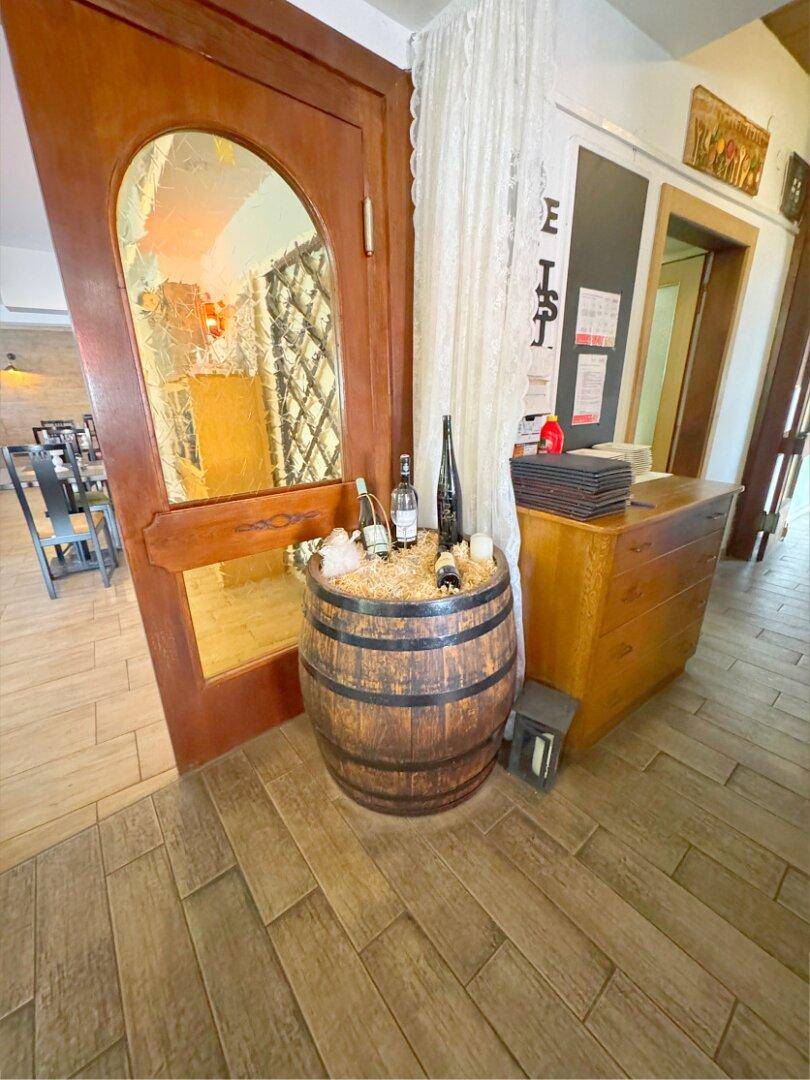Eingangsbereich mit Holzboden, rustikalem Weinfass und Spiegel in traditionellem Stil.