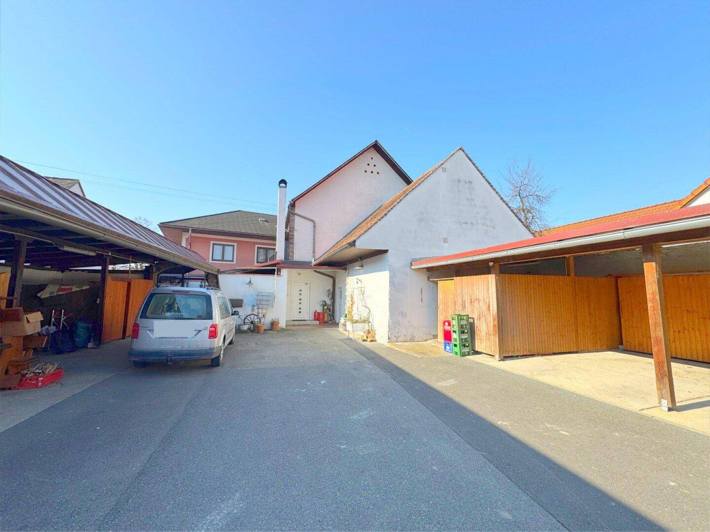 Hinterhofbereich mit Zufahrt, weiteren Carports und Nebengebäuden.