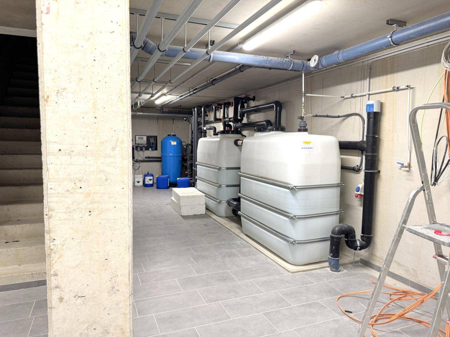 Technikraum mit Wasseraufbereitungsanlagen und Lagertanks im Untergeschoss.