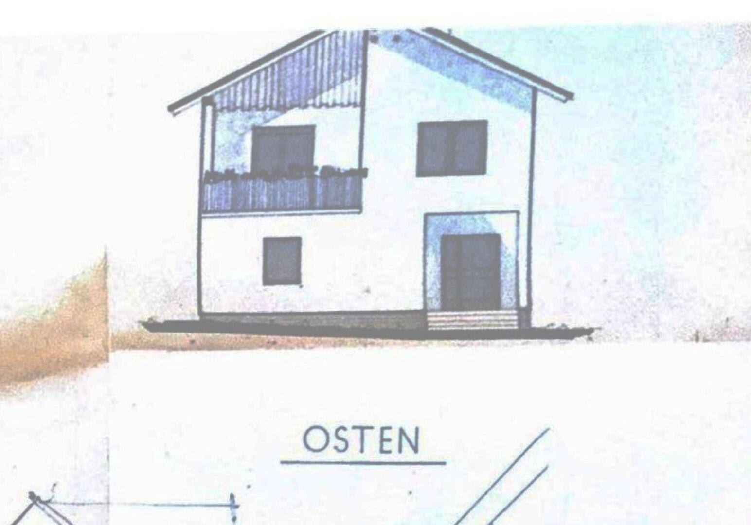 Ansicht des Hauses von Osten, zeigt die Fassade mit Balkon und Fenstern.