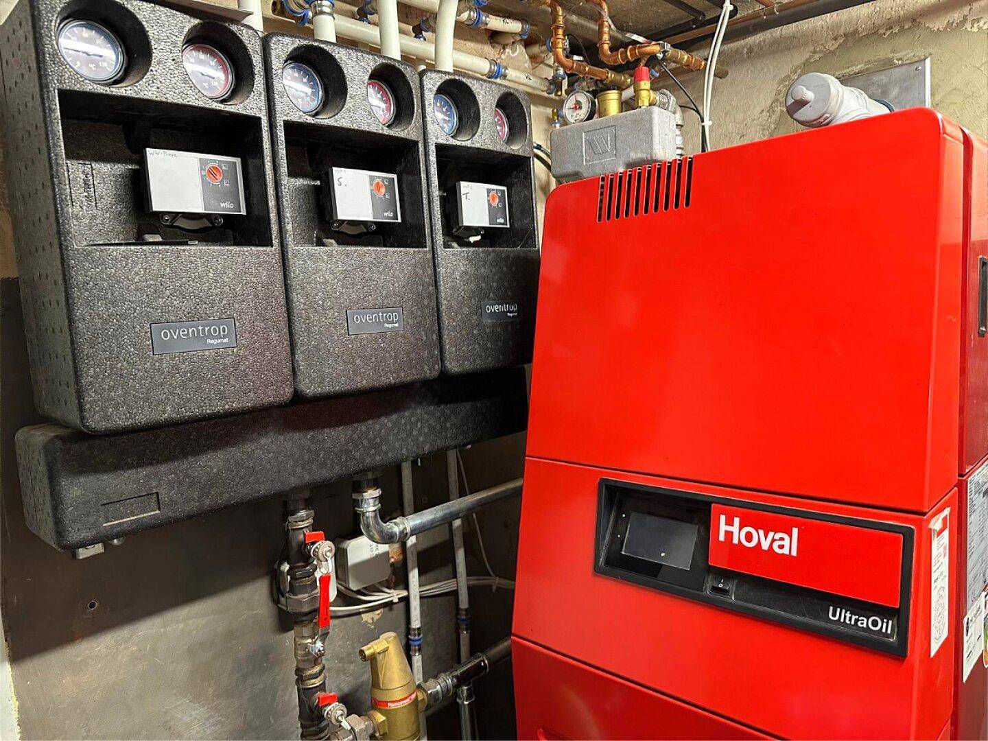 Heizungsanlage mit Ölkessel und Verteilern in einem Technikraum für die Wärmeversorgung.