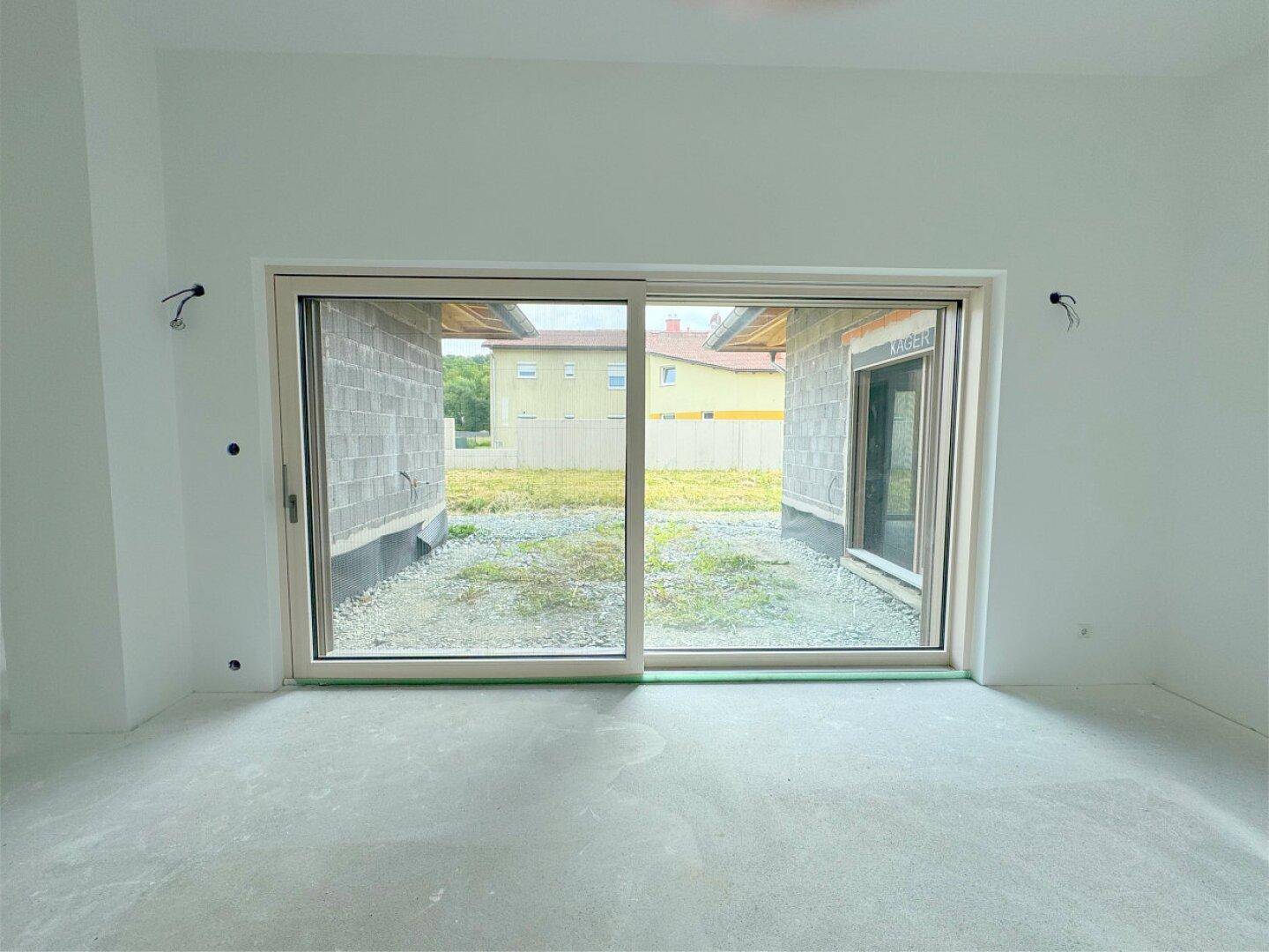 Große Schiebetür im Wohnzimmer bietet Zugang zum Garten und viel natürliches Licht.