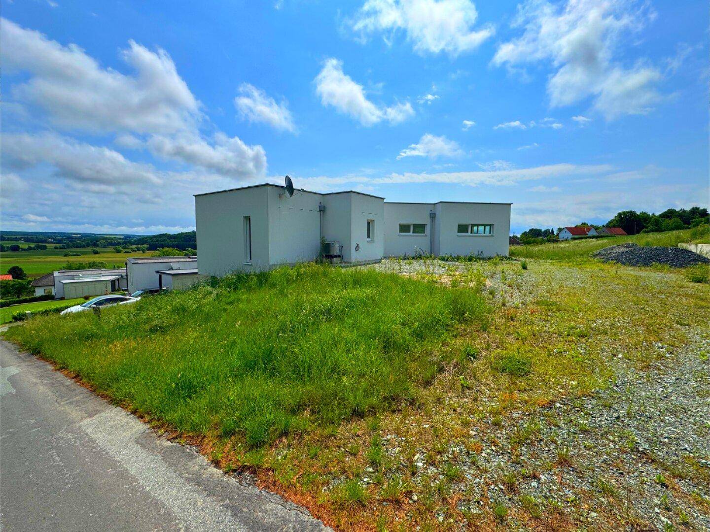 Modernes Haus in ländlicher Umgebung mit weitem Blick und unberührtem Grundstück.