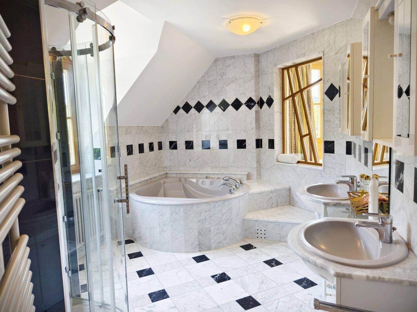 Luxuriöses Badezimmer mit Marmorfliesen, Eckbadewanne und separater Dusche.