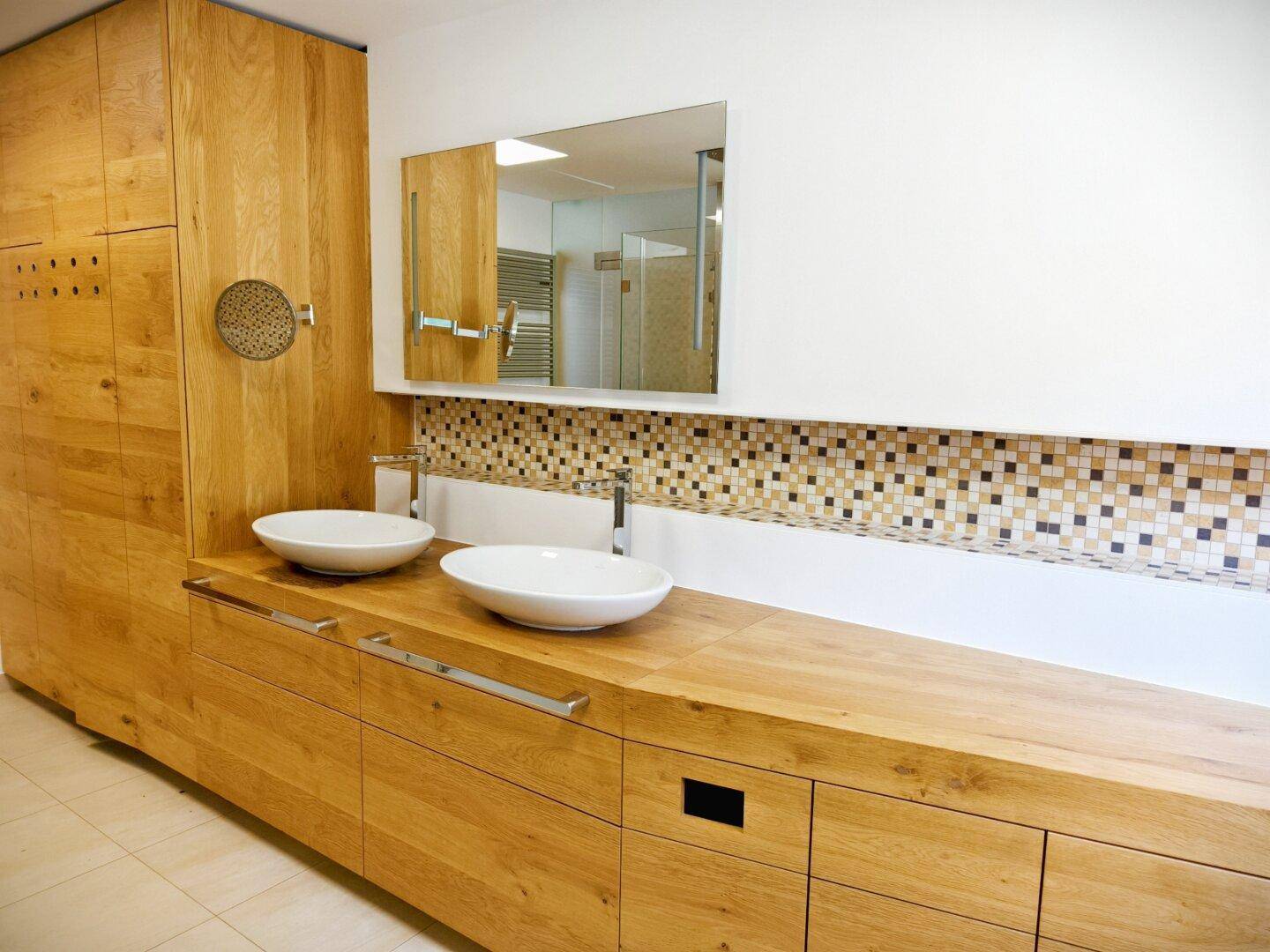 Modernes Badezimmer mit Holzwaschtisch, zwei Aufsatzwaschbecken und Mosaikfliesen.