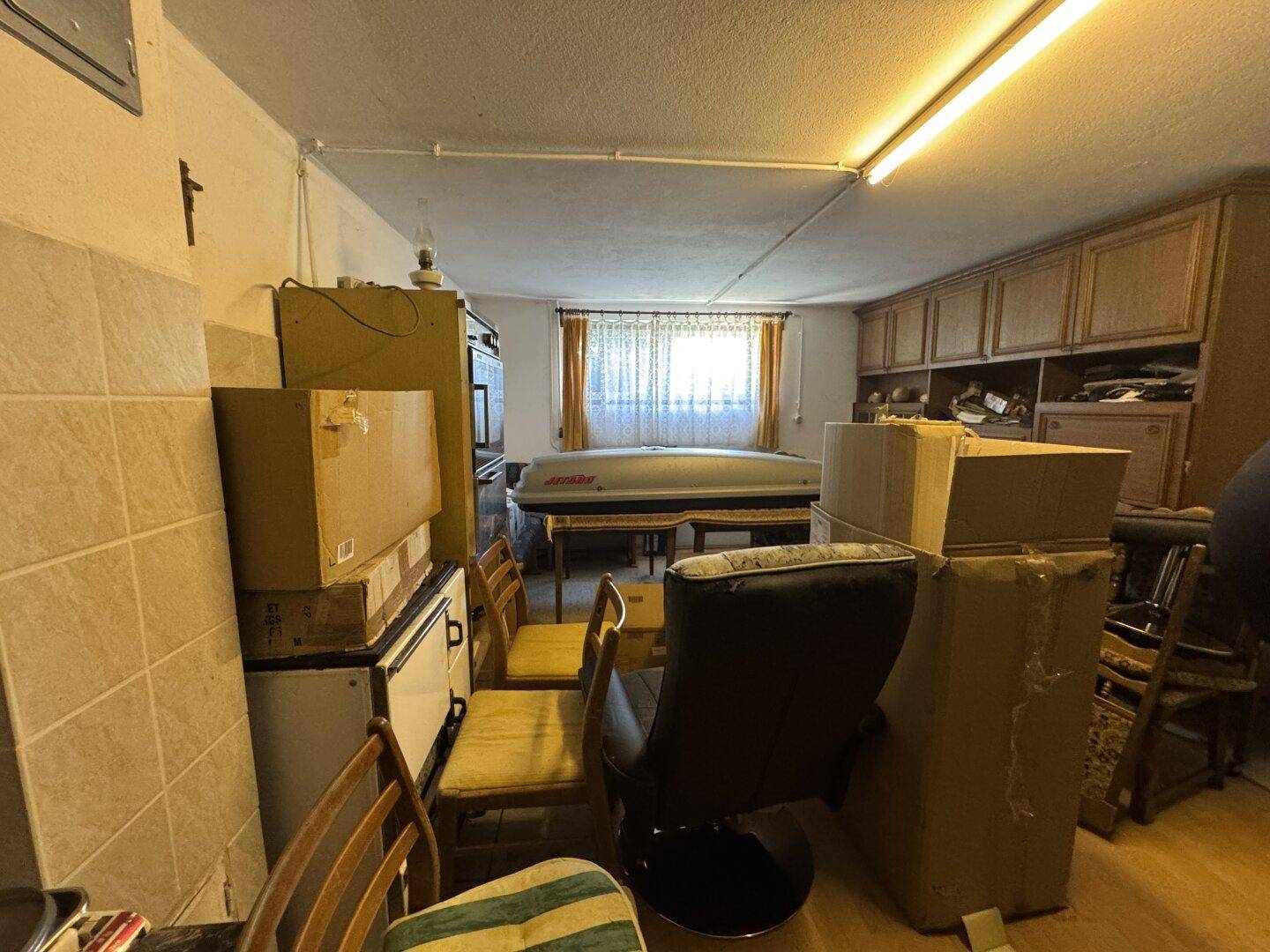 Abstellraum mit Schränken, einem Fenster und verschiedenen Gegenständen, bietet viel Stauraum.