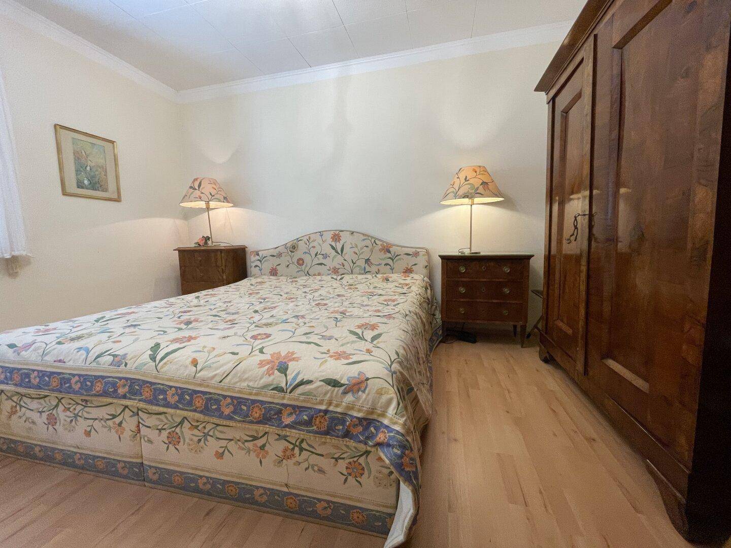 Schlafzimmer mit Doppelbett, Nachttischen und großem Kleiderschrank.