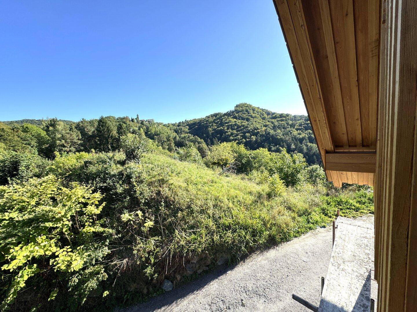 Weitläufiger Blick auf bewaldete Hügel und die Landschaft von einem unfertigen Außenbereich.