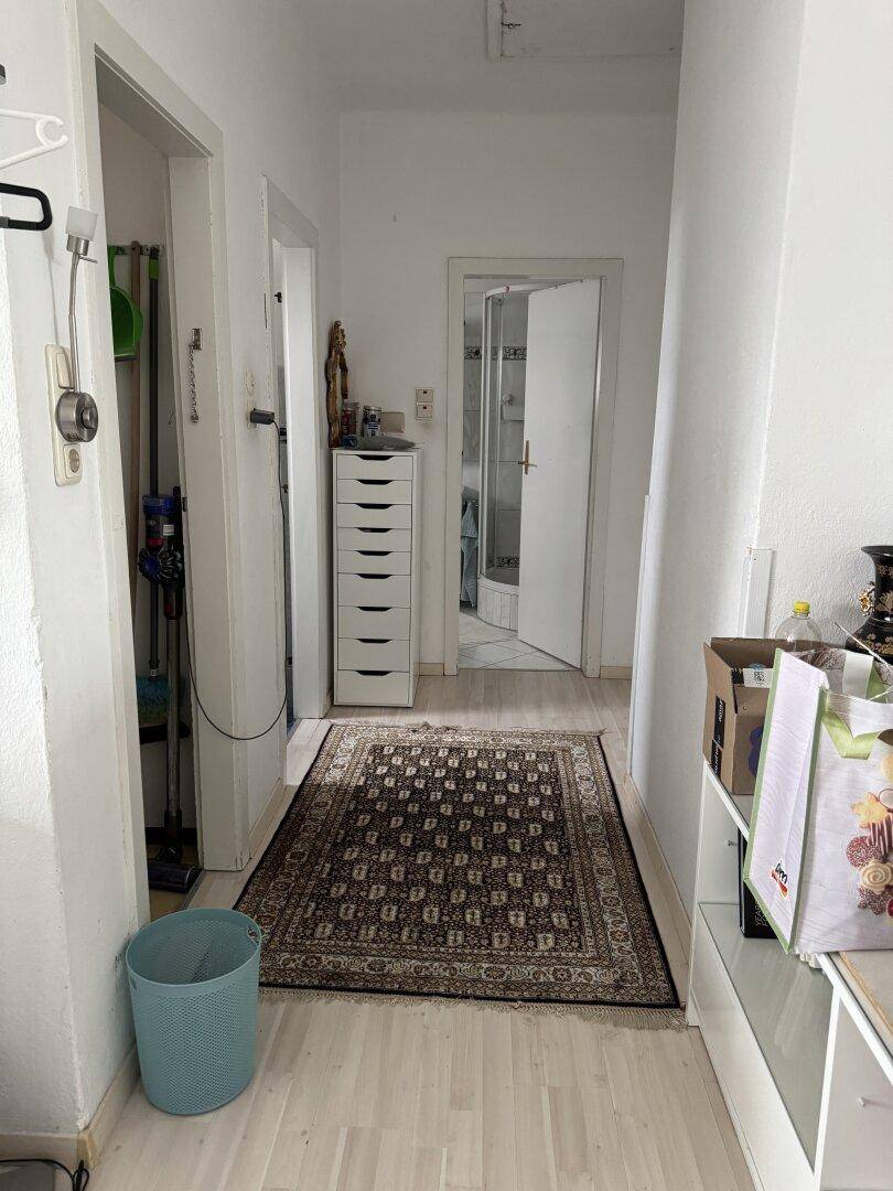 Flur mit Laminatboden, Teppichläufer und Zugang zu weiteren Räumen.