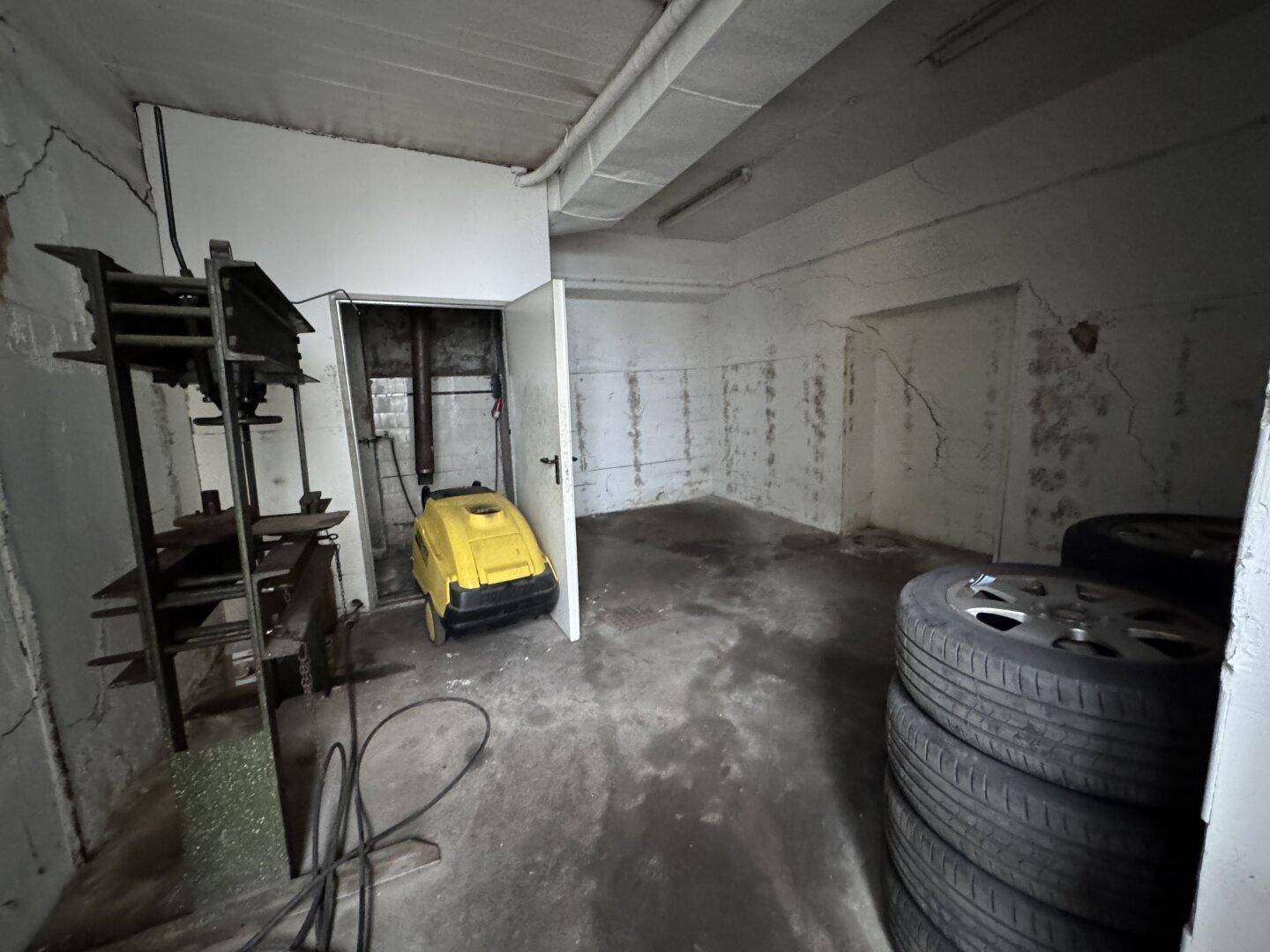 Kellerraum mit Reifenlagerung und sichtbaren Rohren an der Wand.