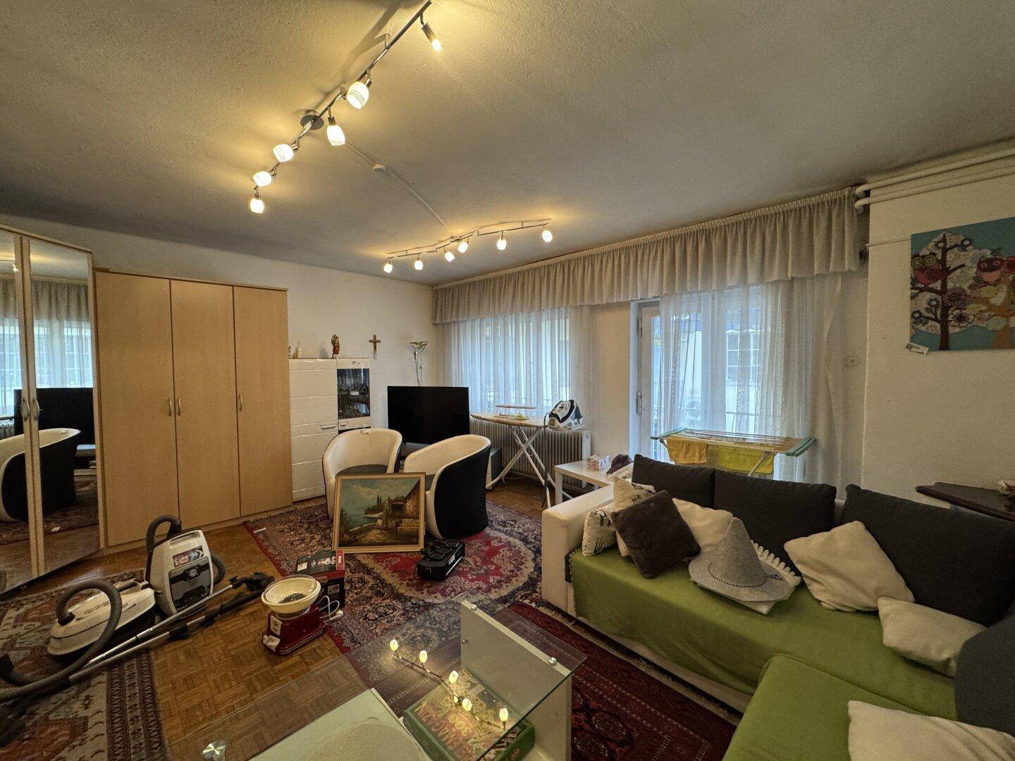 Wohnzimmer mit Parkettboden, Sofa und verschiedenen Möbeln.