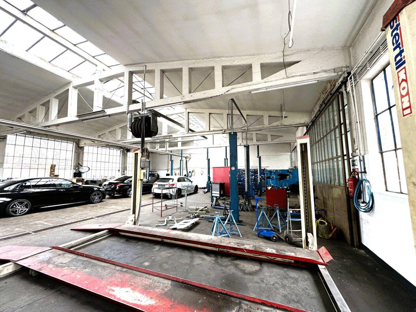 Große Werkstatthalle mit Hebebühnen und viel Tageslicht.