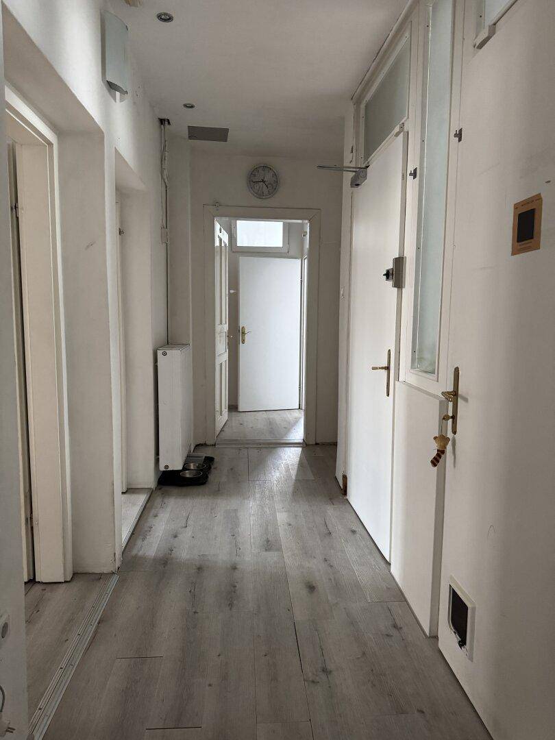 Heller Flur mit Laminatboden und weißen Türen.