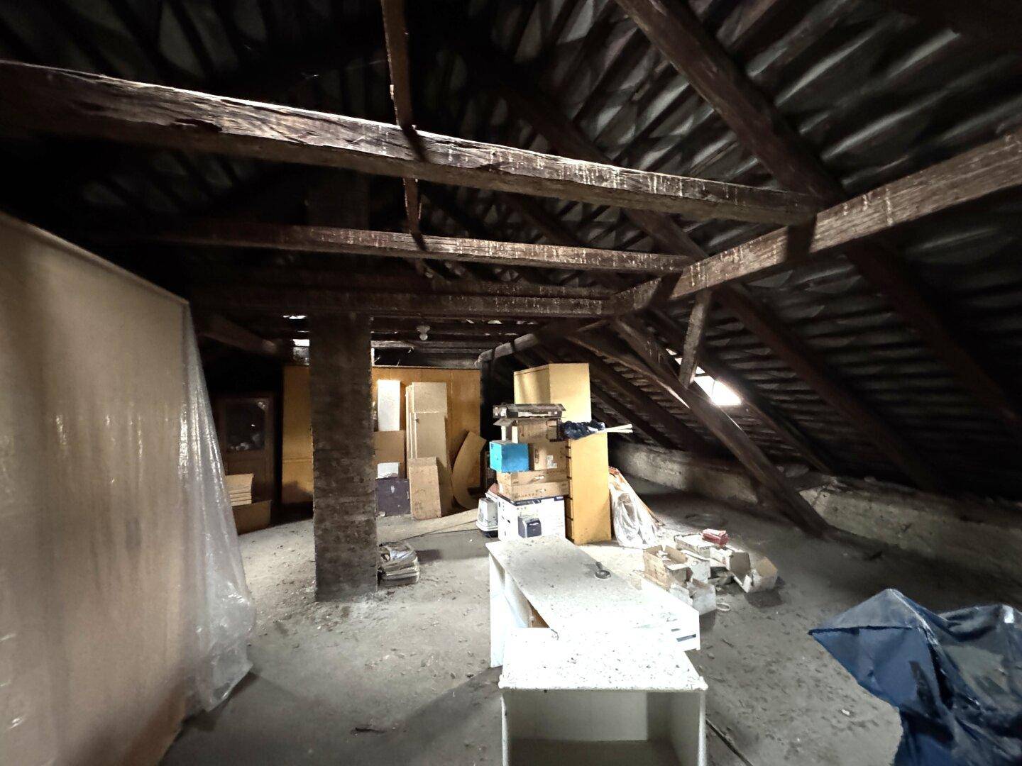 Dachboden mit sichtbaren Holzbalken und Lagerflächen.