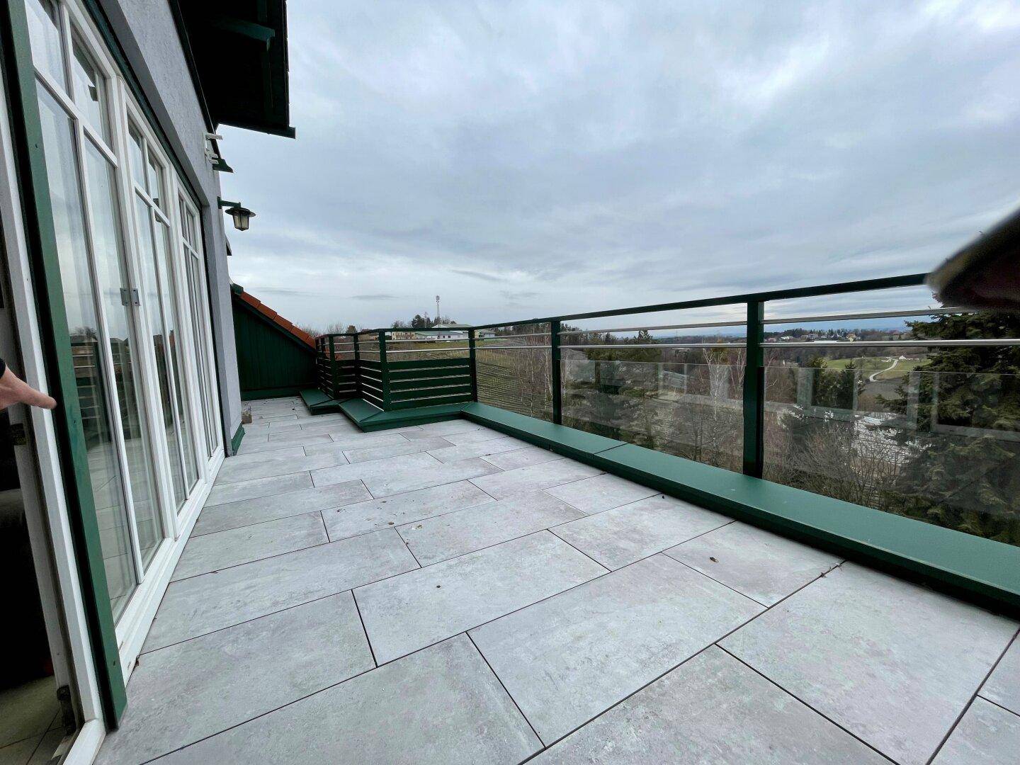 Geräumiger Balkon mit Fliesenboden und moderner Glasbrüstung, bereit zur Gestaltung.