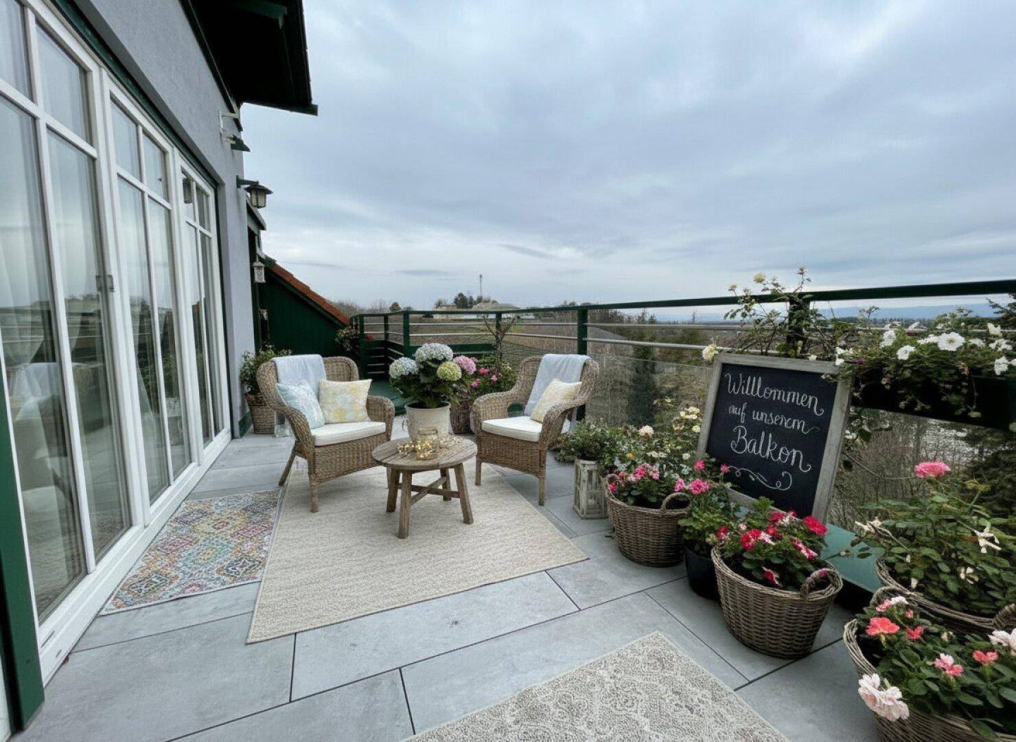 Gemütlicher Balkon mit Sitzgelegenheiten, vielen Pflanzen und weitem Ausblick.