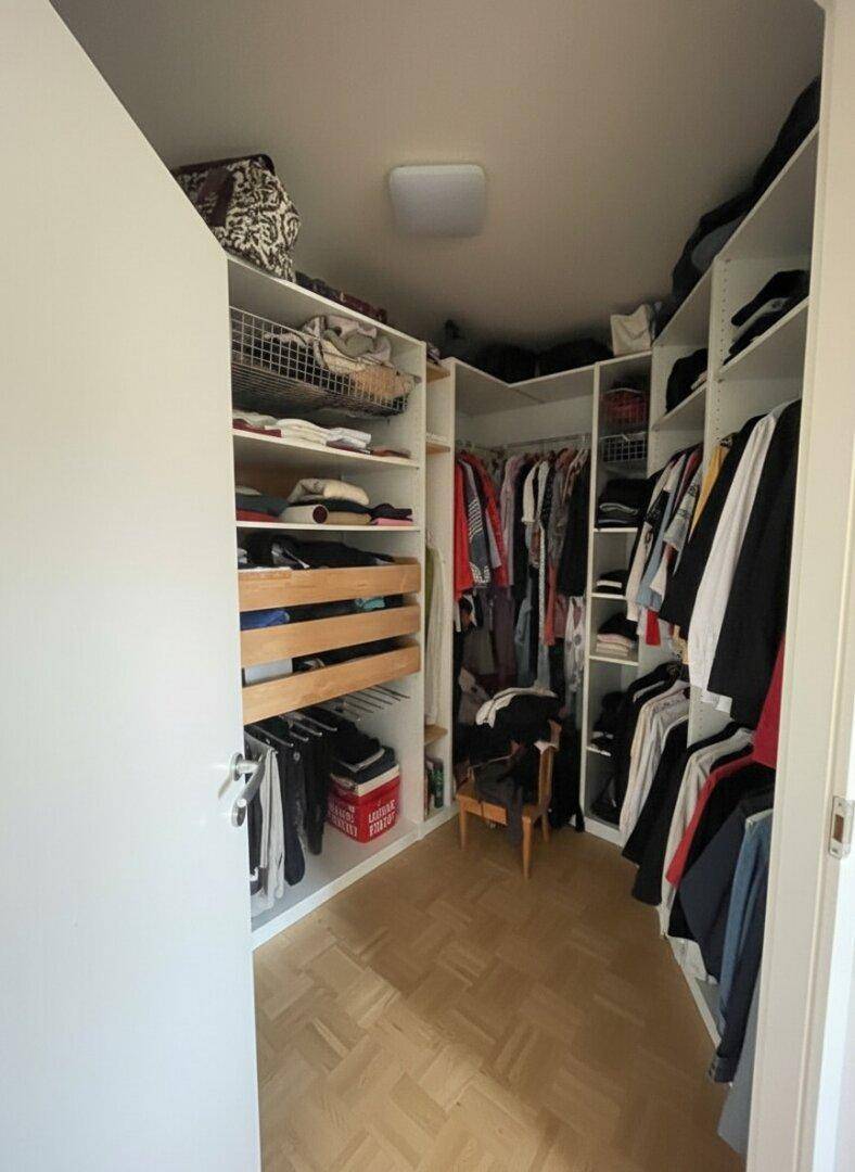 Praktischer begehbarer Kleiderschrank mit vielen Regalen und Aufbewahrungsmöglichkeiten.