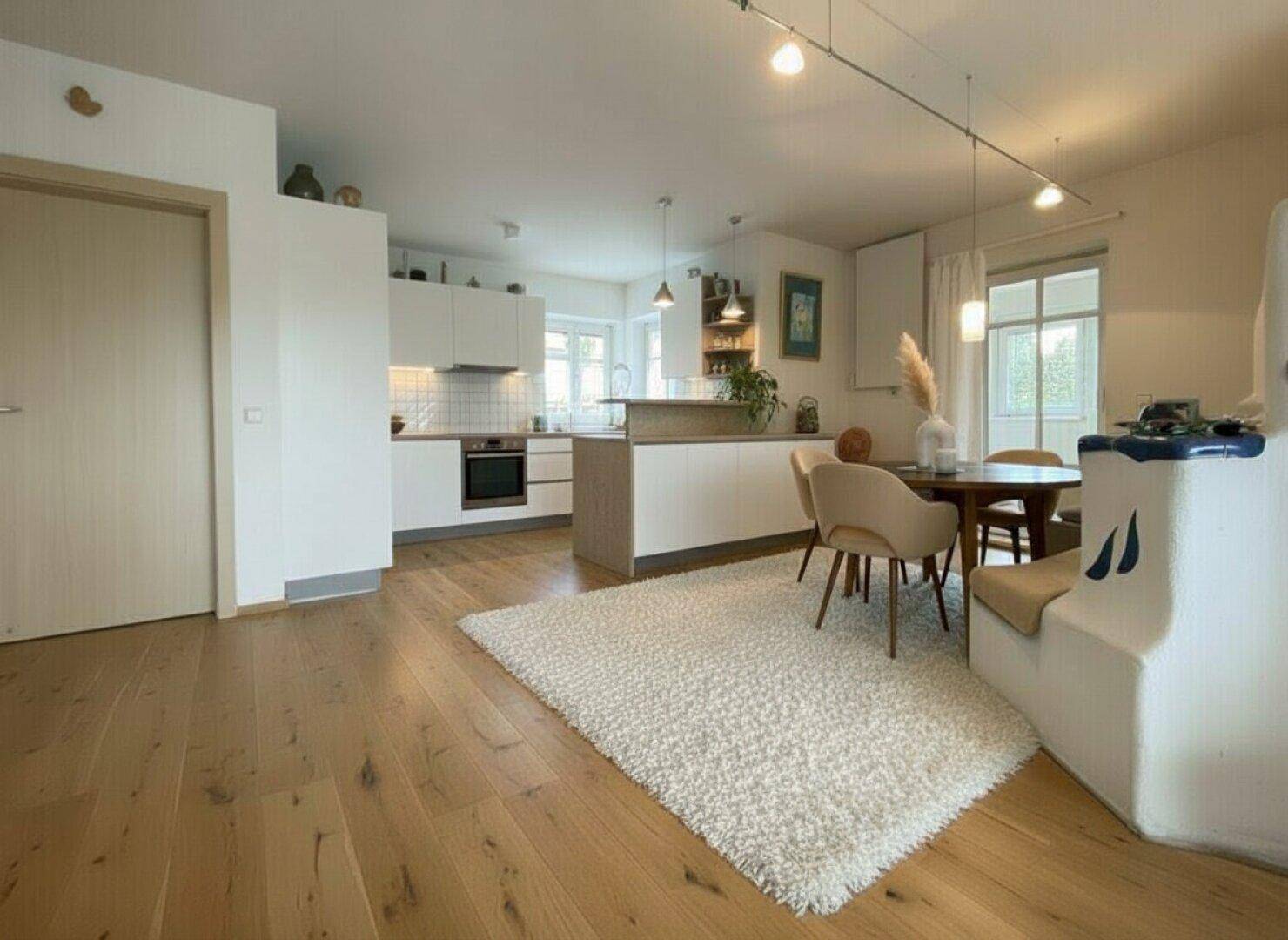 Renovierte offene Küche mit modernen weißen Schränken, Holzboden und Essbereich.