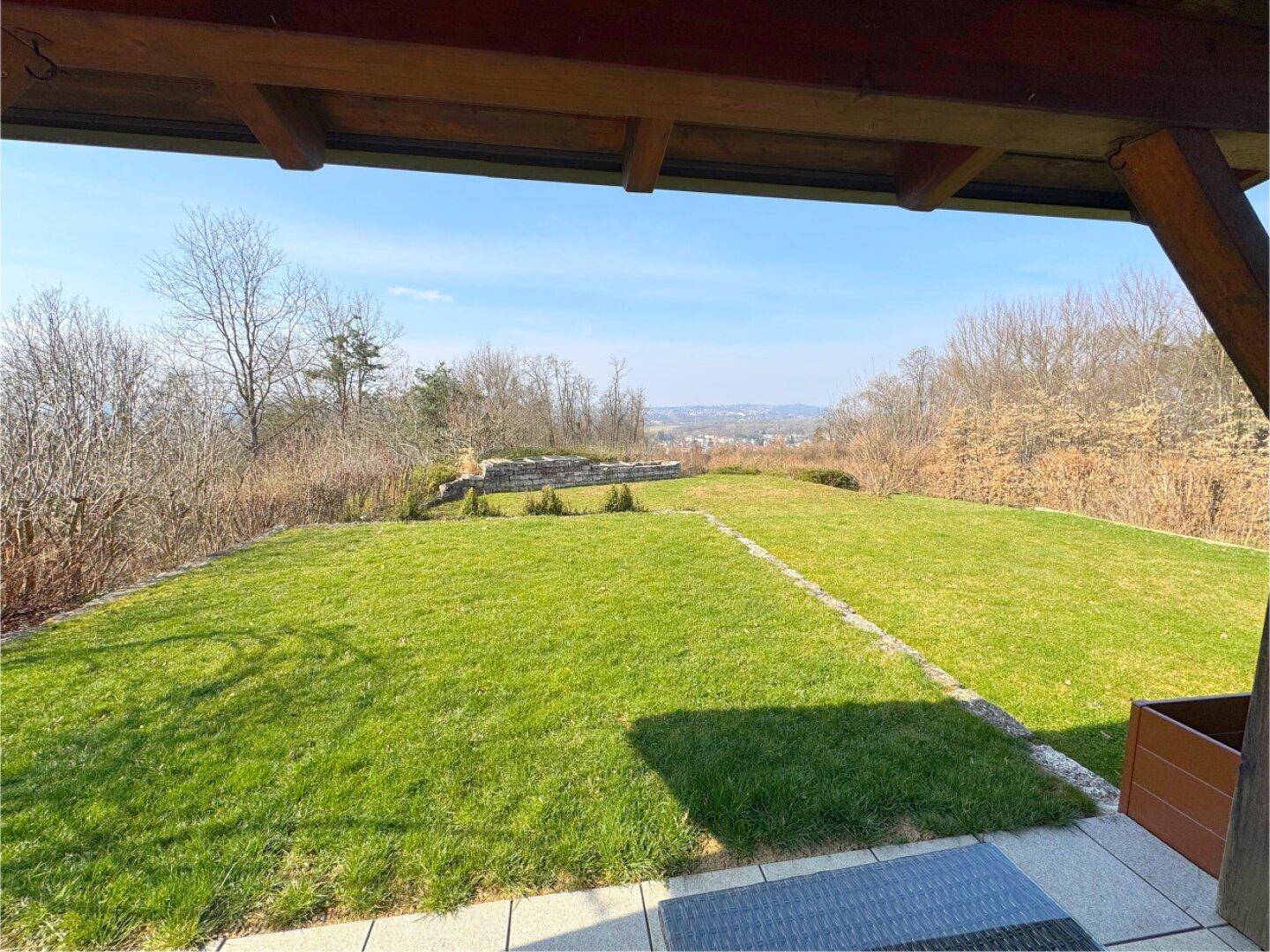 Weitläufiger Gartenbereich mit gepflegtem Rasen und Panoramablick auf die umliegende Landschaft.