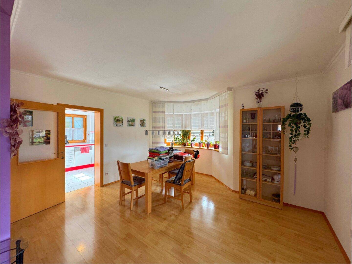 Heller Essbereich mit Holztisch, Stühlen und großen Fenstern für viel Tageslicht.