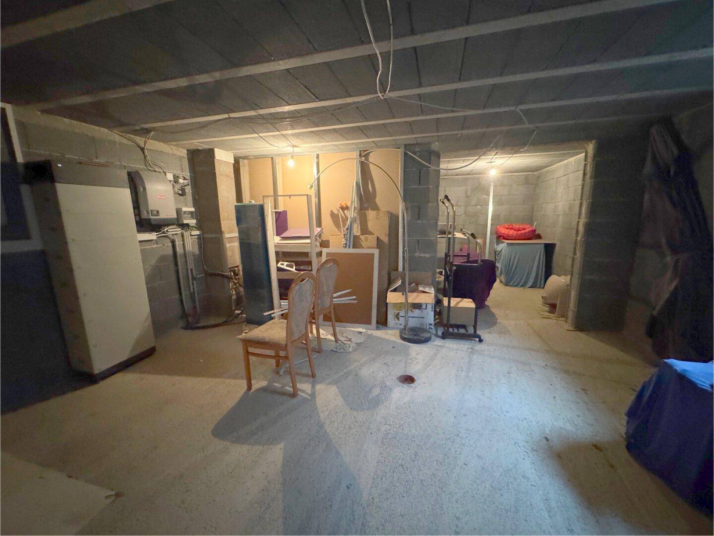 Unfertiger Kellerraum mit Betonwänden und -decken, bereit für den Ausbau.