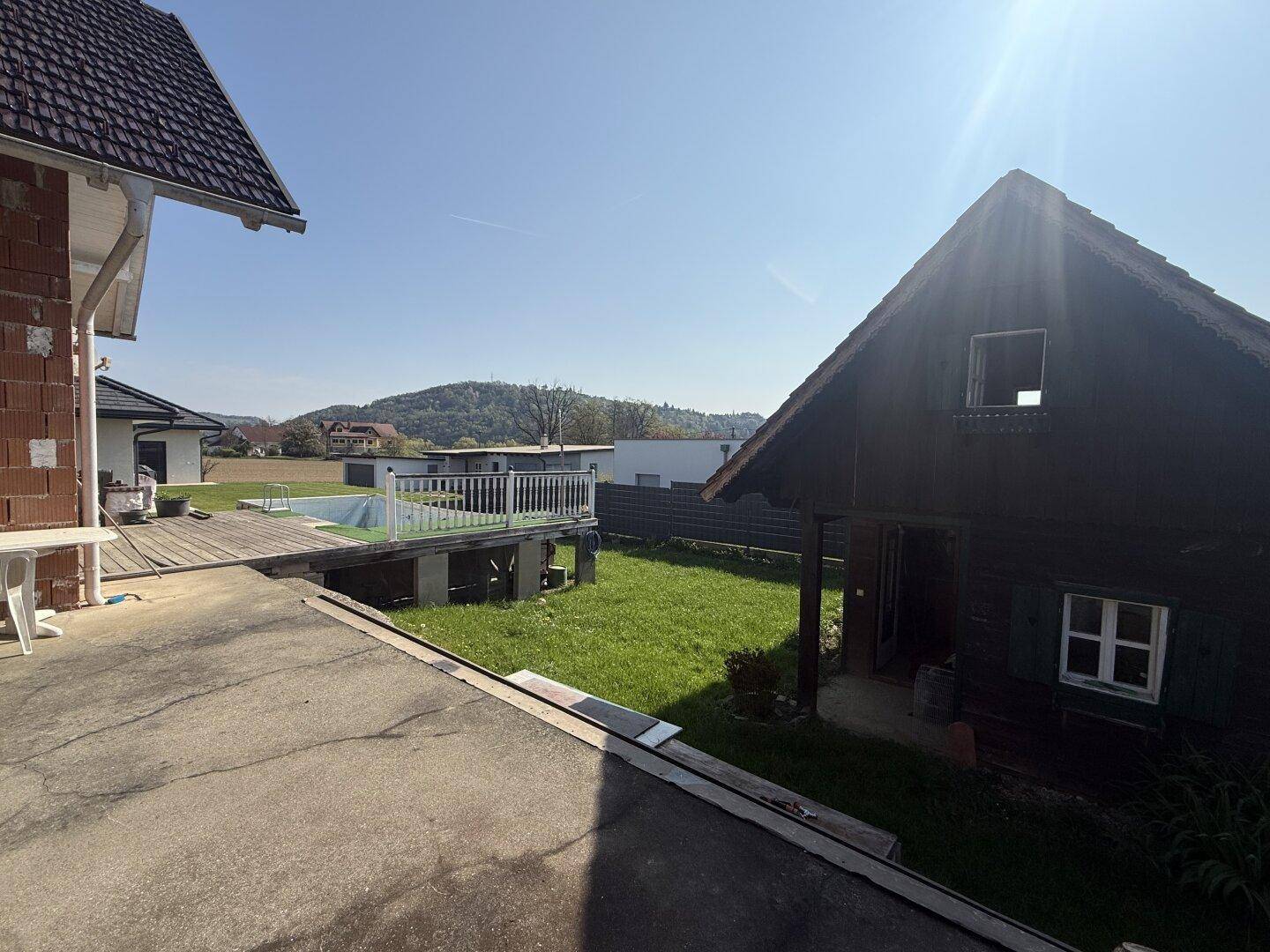 Weitläufiger Garten mit Holzhaus und Blick auf die umliegenden Hügel.