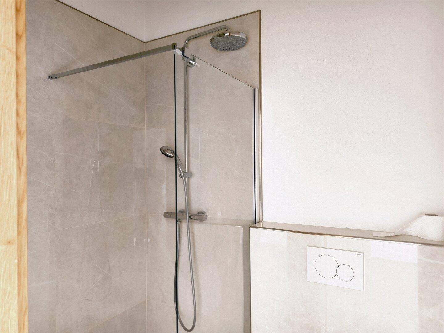Moderne Dusche mit Regenduschkopf und Glasabtrennung in einem hellen Badezimmer.