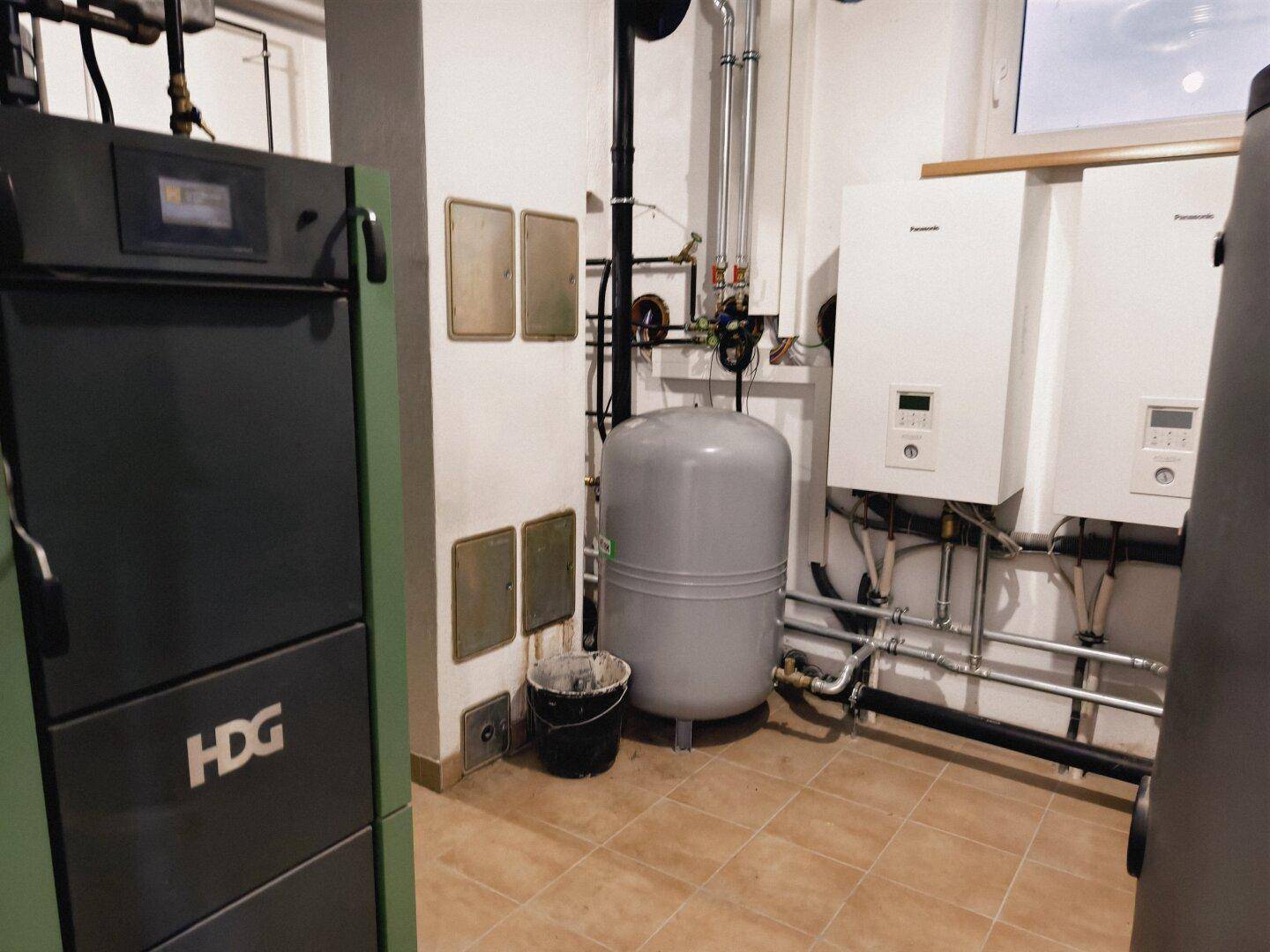 Technikraum mit Heizungsanlage, Warmwasserspeicher und verschiedenen Installationen.
