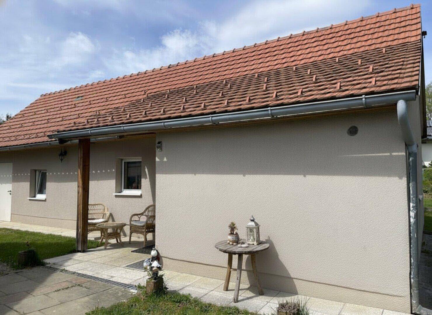 Nebengebäude mit kleiner überdachter Terrasse und Ziegeldach im ländlichen Stil.
