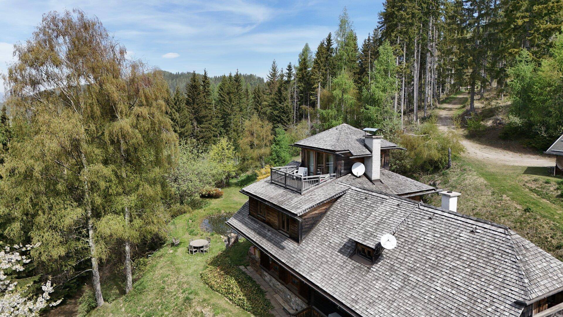 Dachansicht des Holzhauses mit traditionellen Holzschindeln und einer kleinen Dachterrasse.