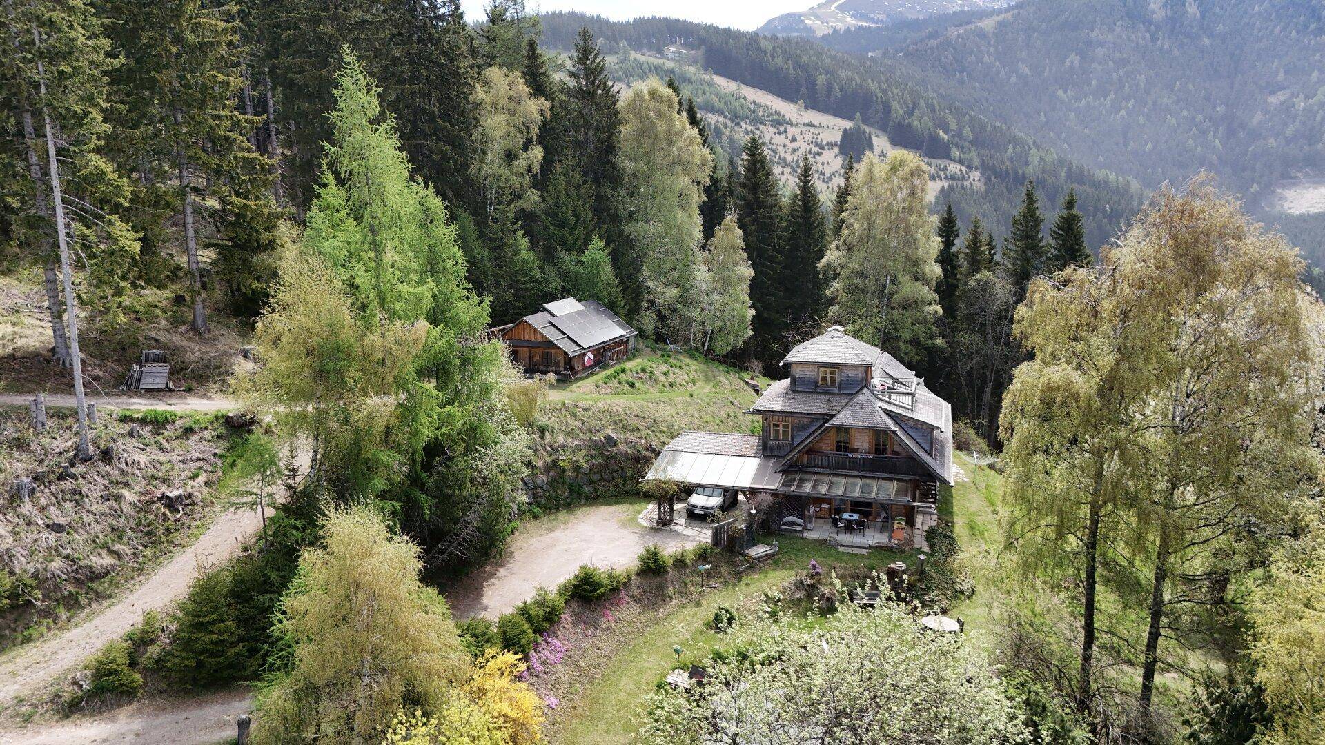 Weitläufiges Anwesen mit Haupthaus und Nebengebäude, umgeben von Wald und Natur.