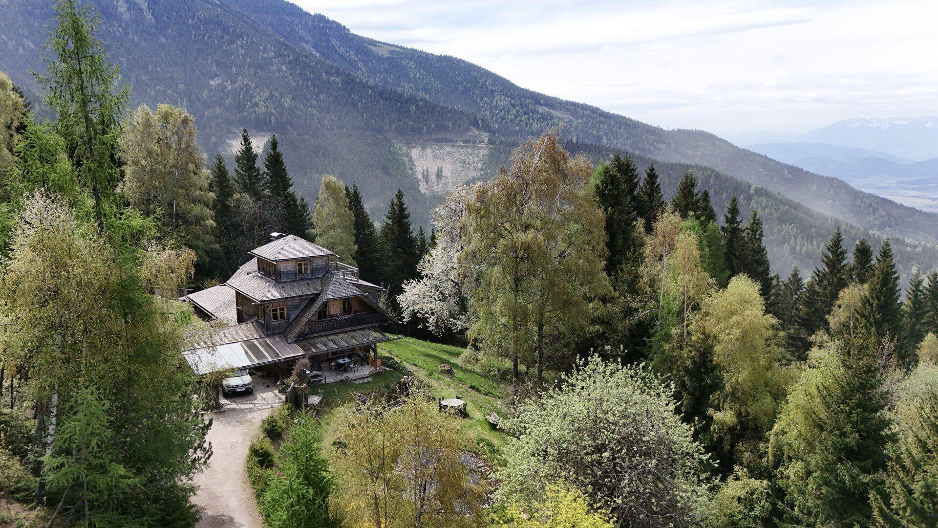 Großzügiges Holzhaus in idyllischer Berglage, umgeben von Wald und mit weitem Ausblick.