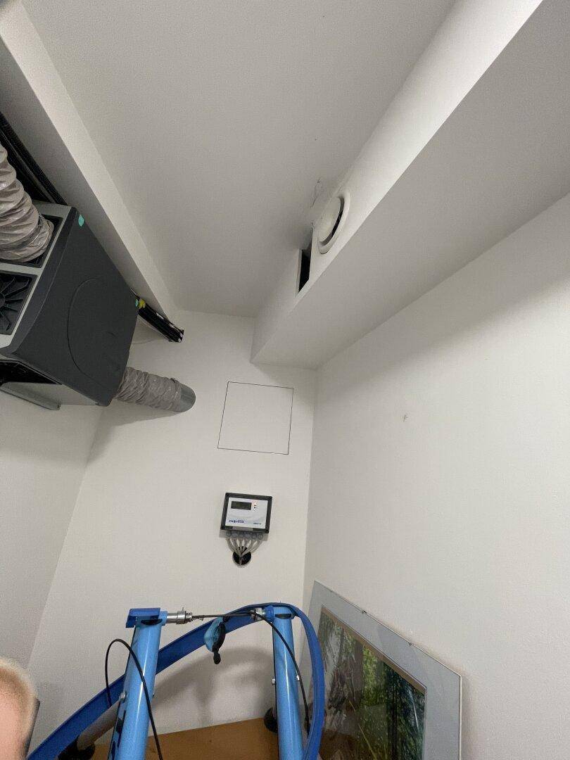 Technikraum mit sichtbaren Lüftungsanlagen und Rohrleitungen, sauber und funktional gestaltet.