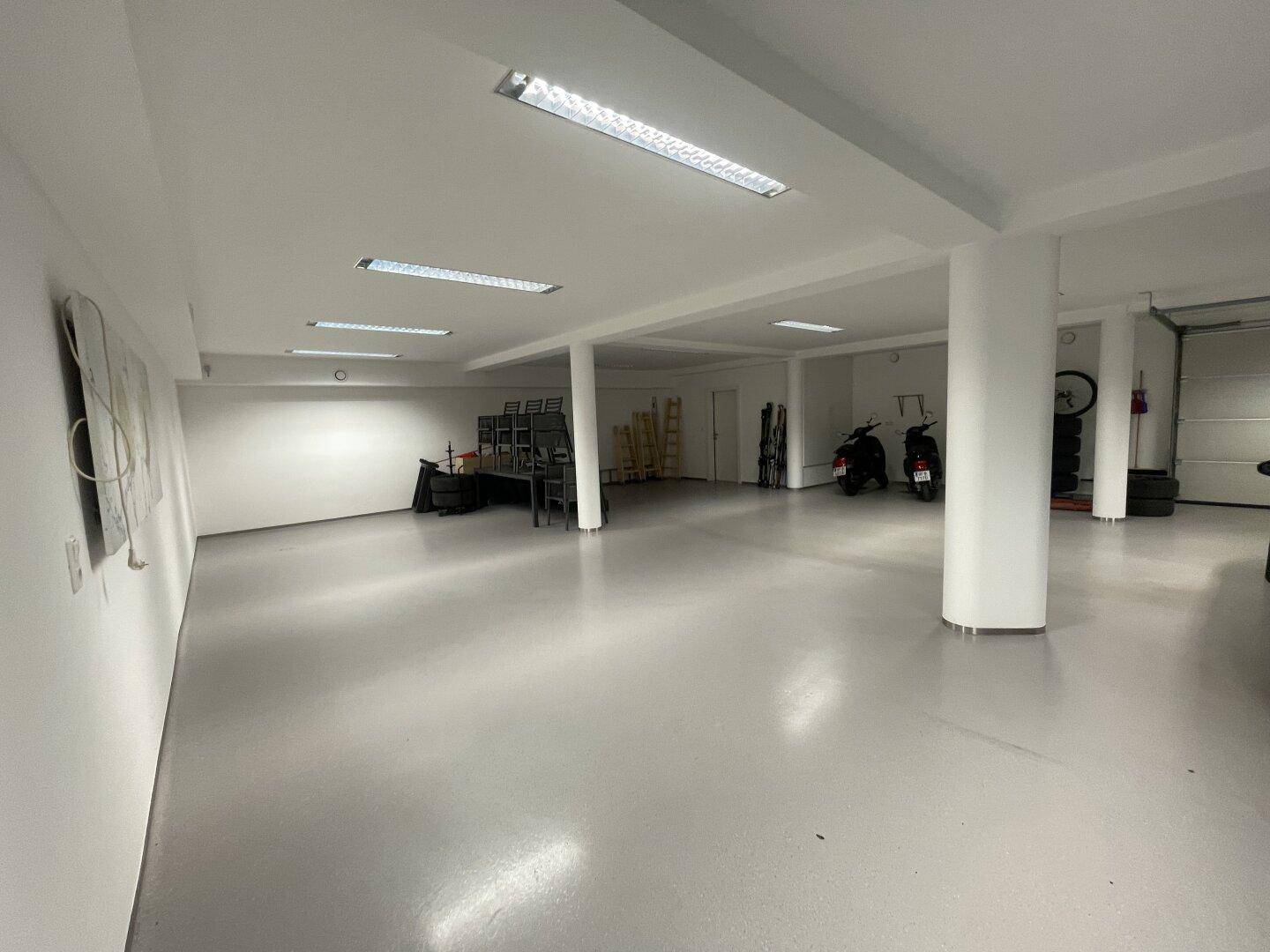 Geräumige und helle Tiefgarage mit mehreren Stellplätzen, Säulen und funktionaler Beleuchtung.