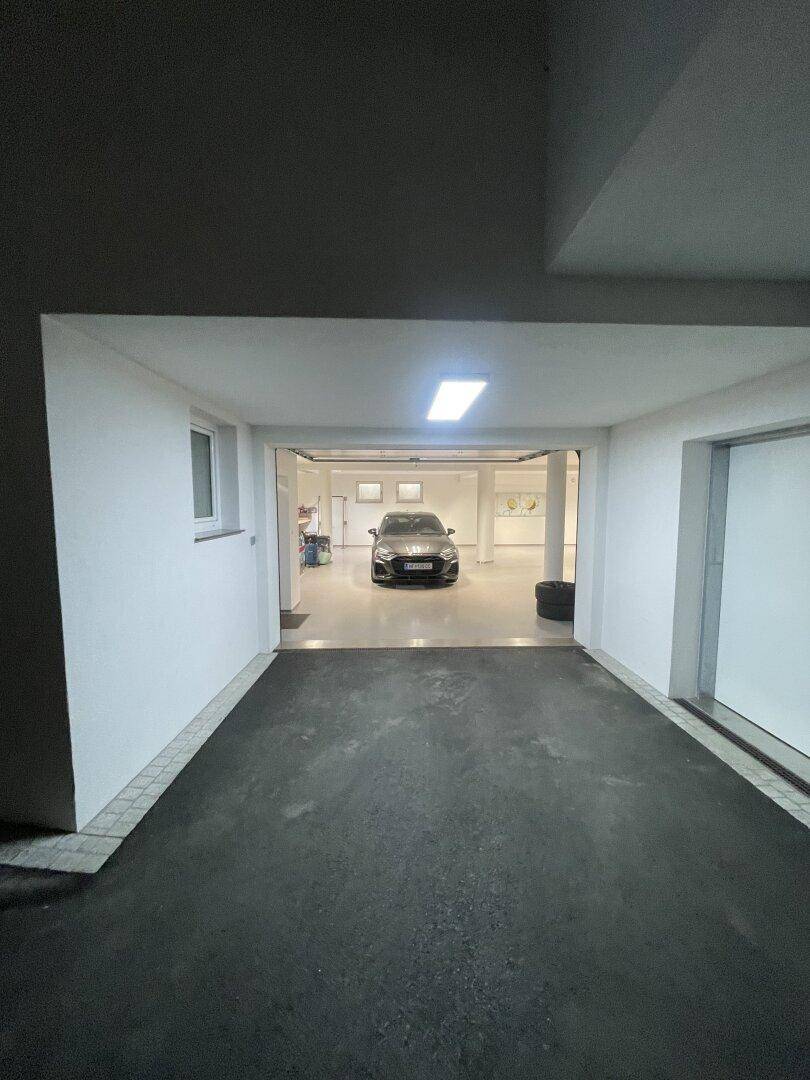 Eingangsbereich einer Tiefgarage, der den Blick auf einen hellen, sauberen Parkbereich mit einem geparkten Auto freigibt.